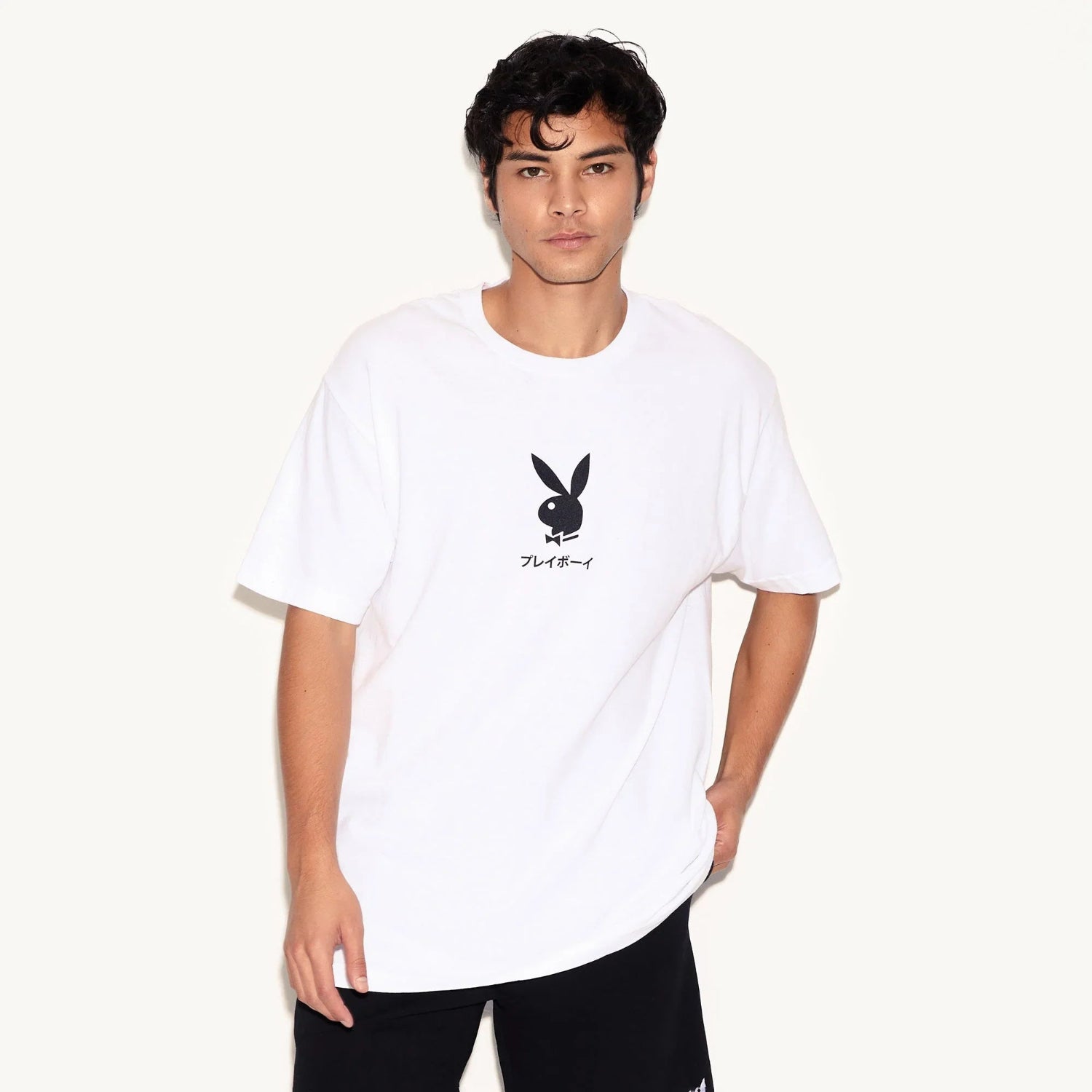 Man wearing white t-shirt with black bunny logo and Japanese text, casual streetwear style