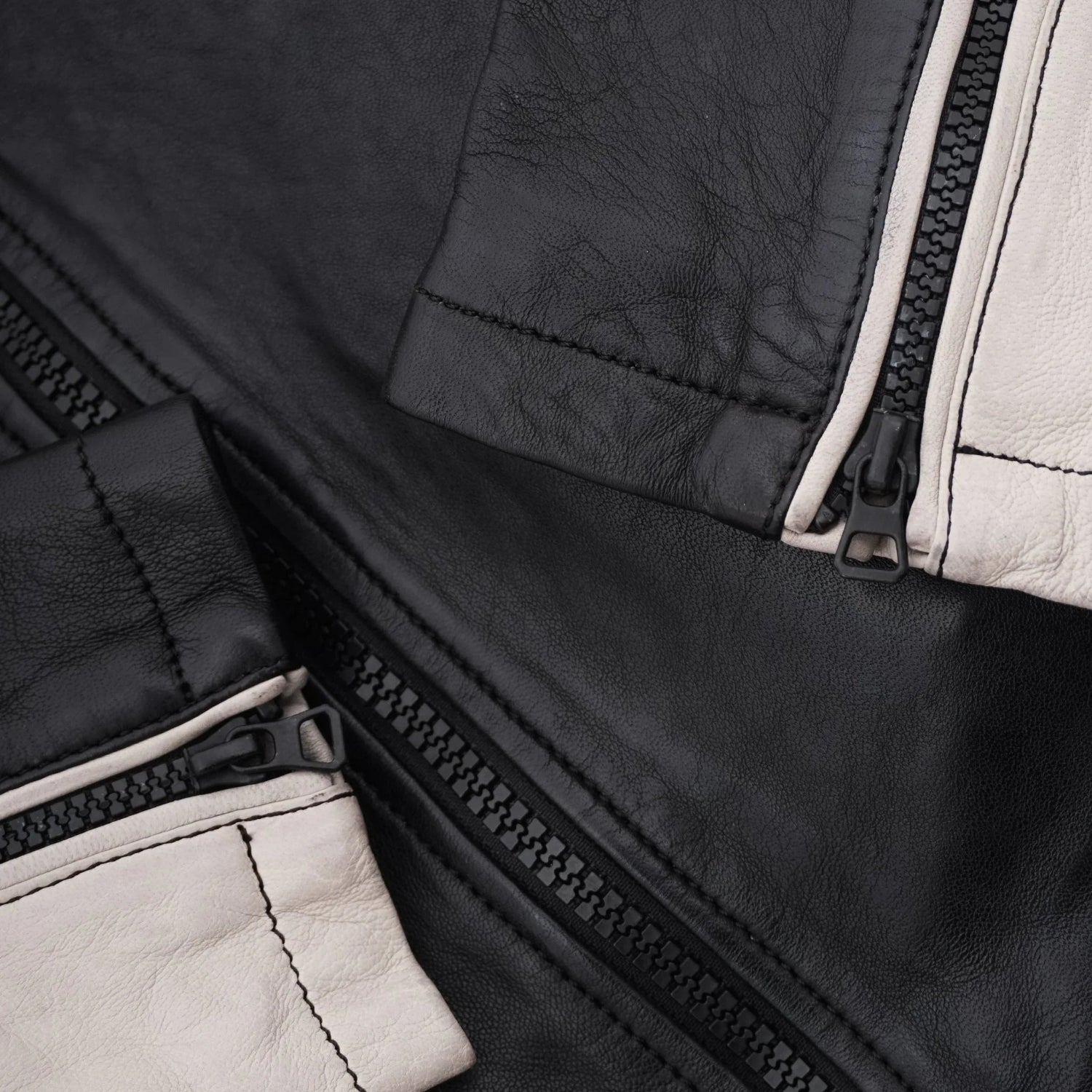 Close-up of black and white men's leather jacket sleeves with zippers