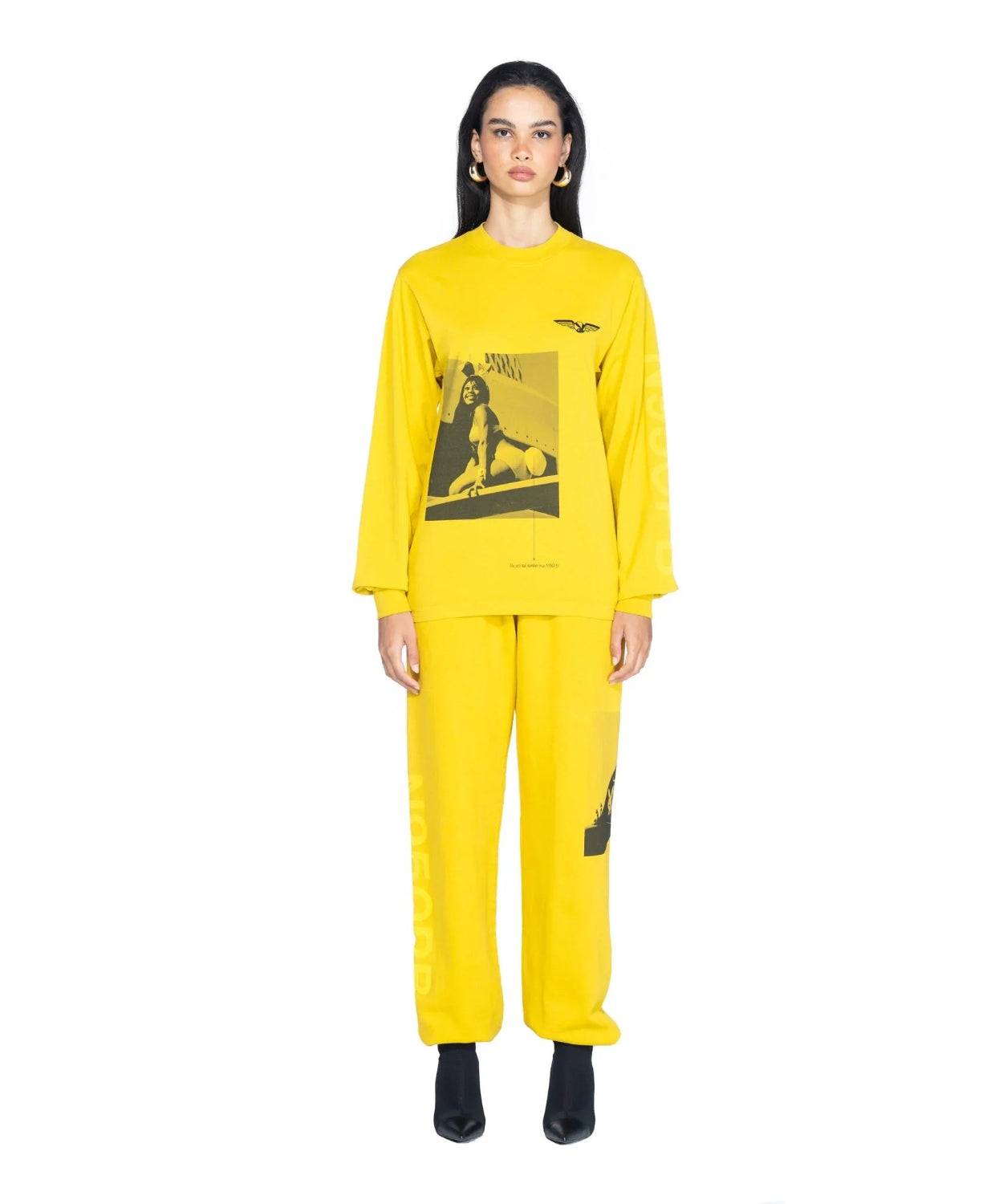 Woman wearing yellow long sleeve graphic t-shirt and matching pants with black boots