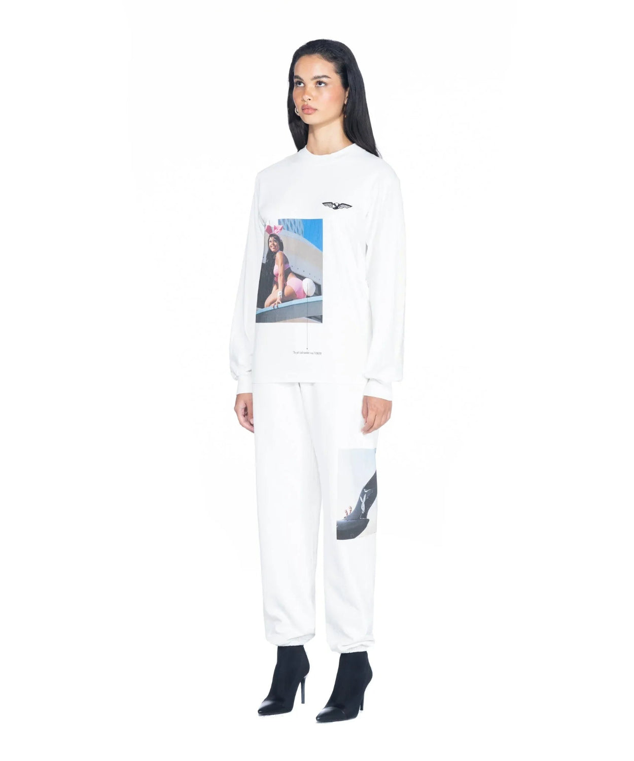 Woman in white graphic long sleeve shirt and matching sweatpants with black heeled boots