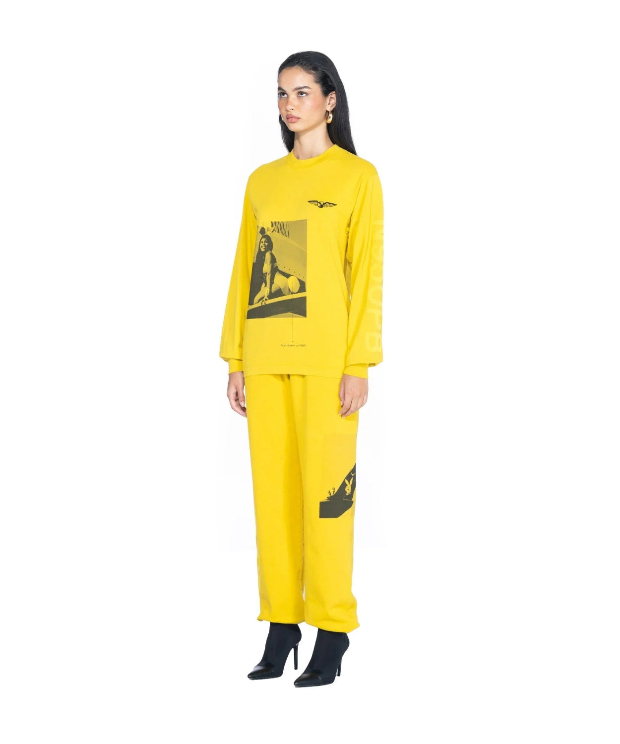 Woman wearing yellow aviation graphic long sleeve T-shirt and matching pants with high heels