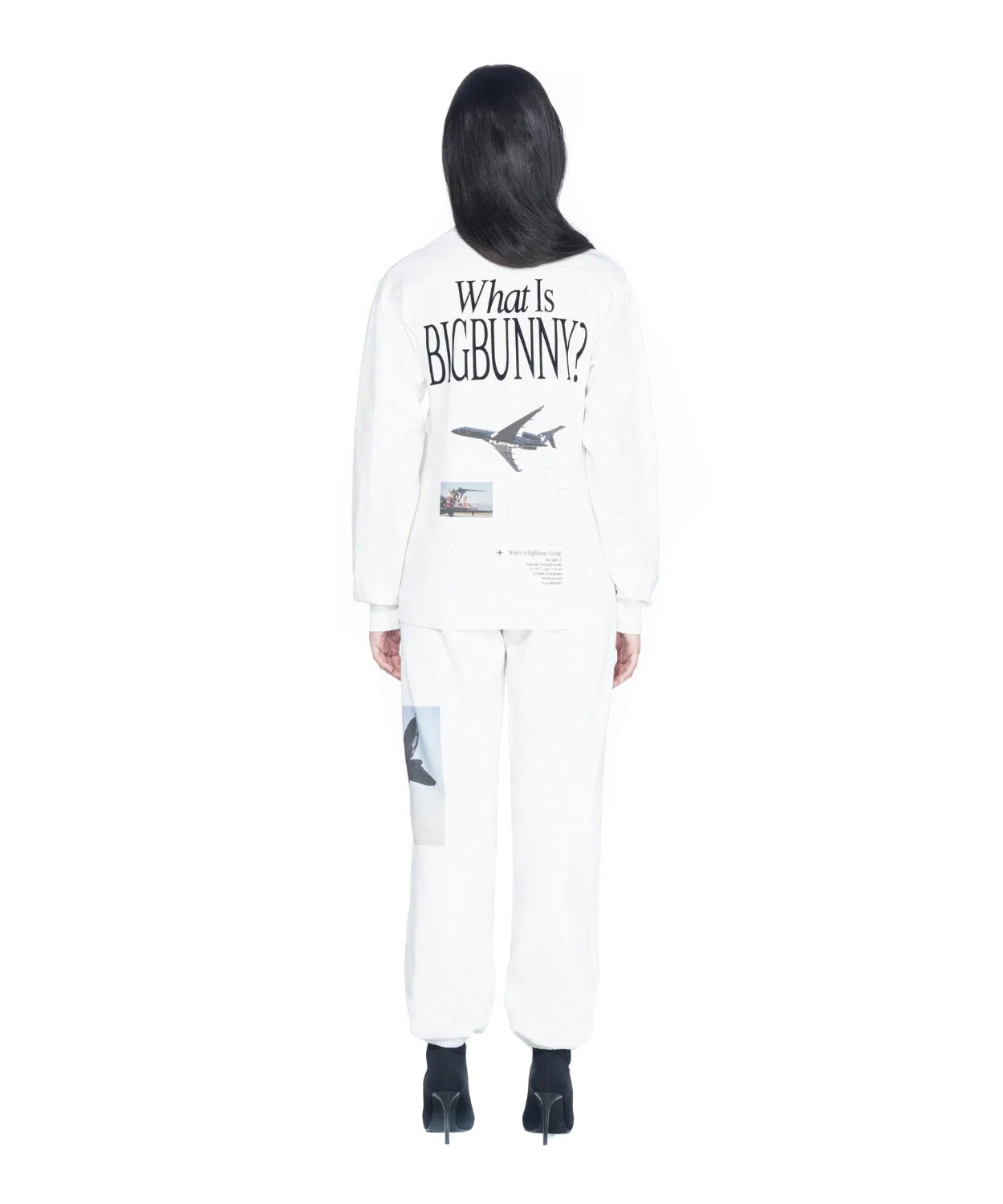 Woman wearing white long sleeve t-shirt with airplane graphic and 'What Is Big Bunny?' text on back