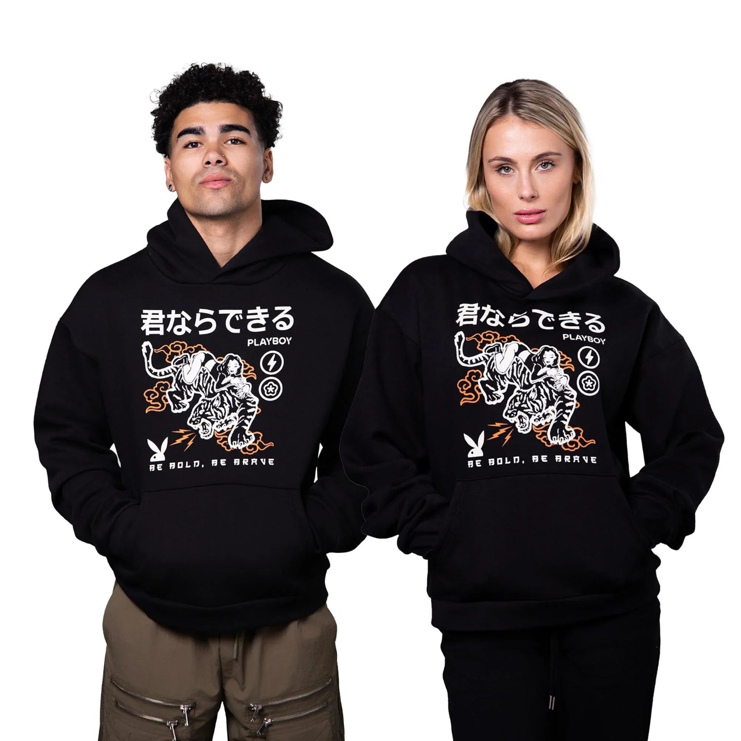 Two models wear black hoodies with tiger graphic, Japanese text, and 'Be Bold, Be Brave' slogan.