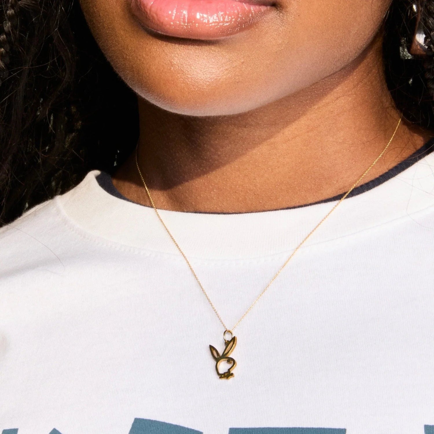 Gold bunny pendant necklace on model wearing white top