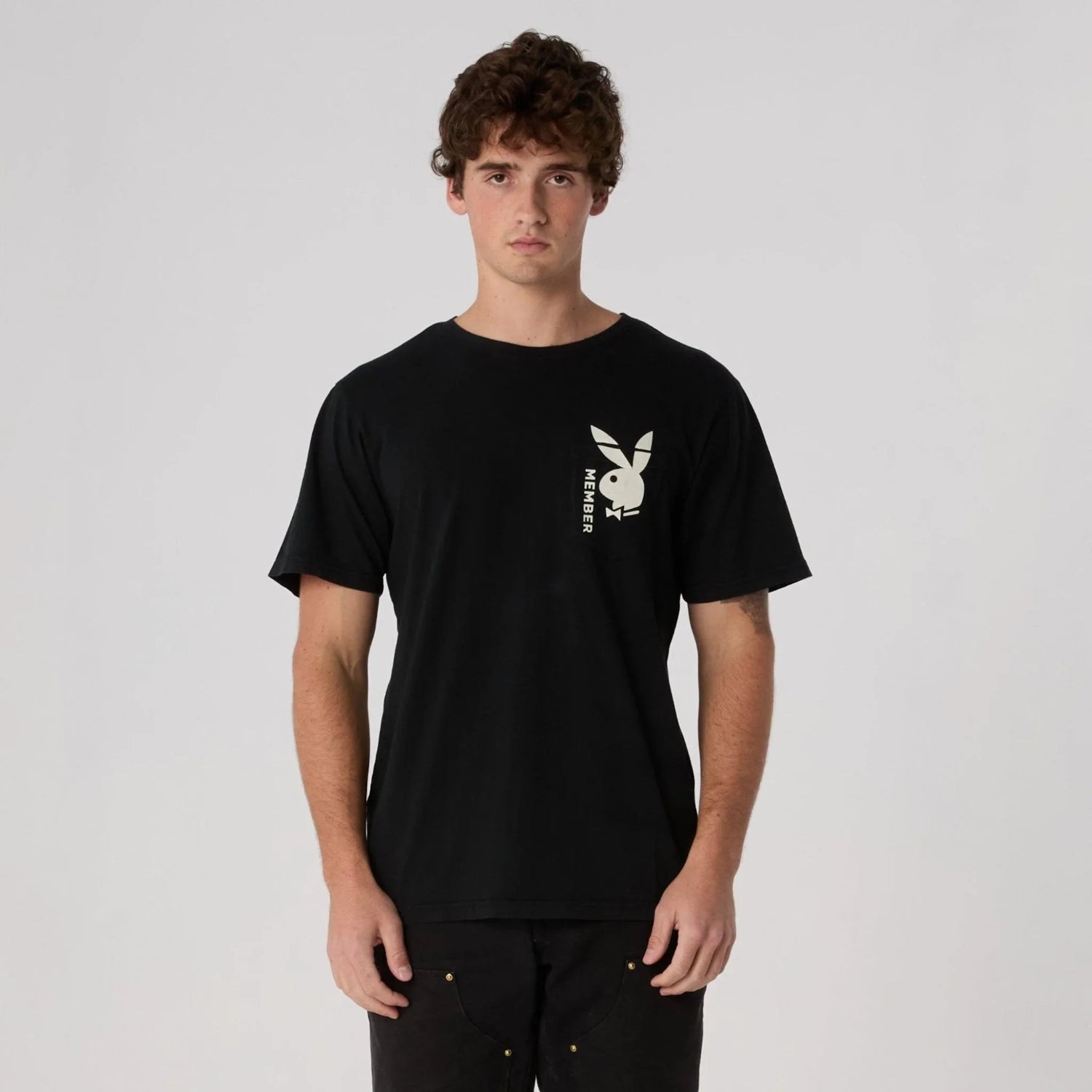 Man wearing black pocket tee with bunny logo and MEMBER text on chest, casual style