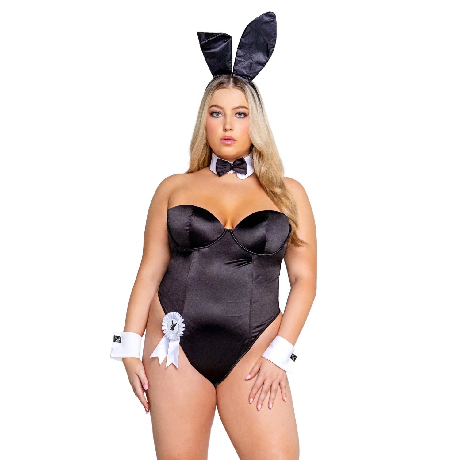 Woman in black satin bunny costume with ears, bow tie, and cuffs, standing against white background.
