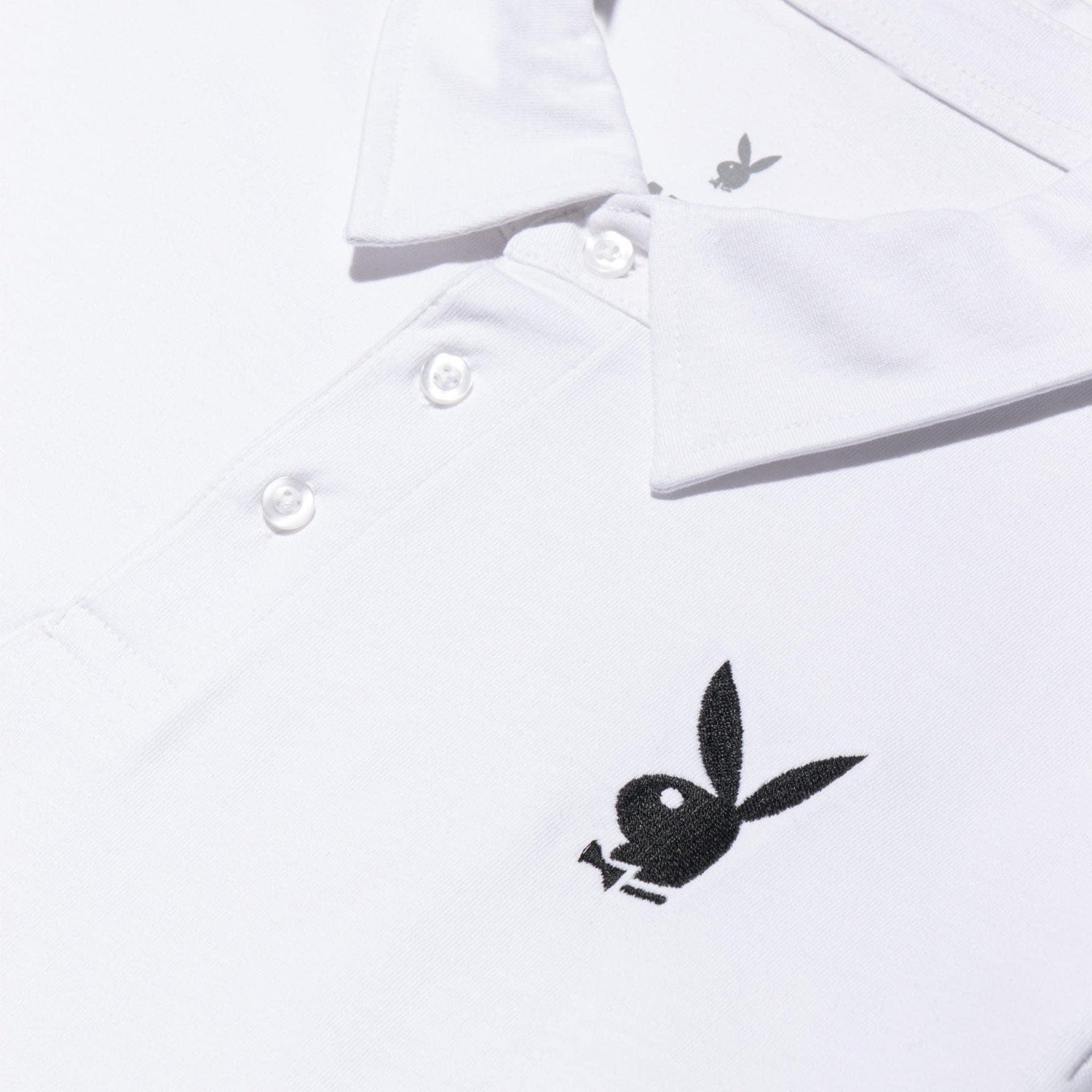 White polo shirt with black embroidered rabbit head logo and three button placket