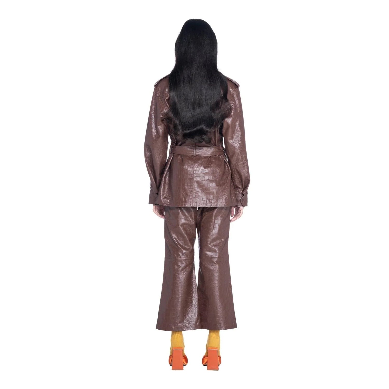 Back view of model wearing brown crocodile-pattern faux leather safari jacket and pants