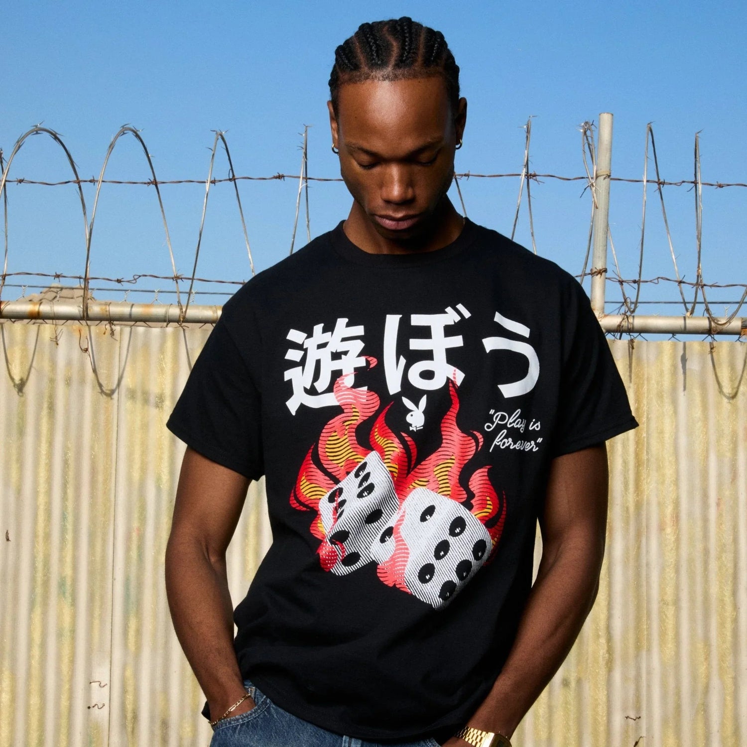 Man wearing black graphic tee with flaming dice and bold Japanese text, casual streetwear style