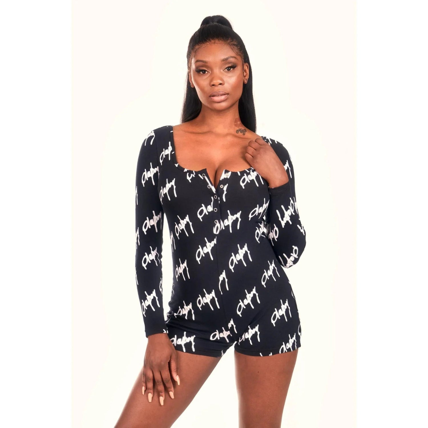 Woman modeling a long sleeve black playsuit with white graffiti script pattern