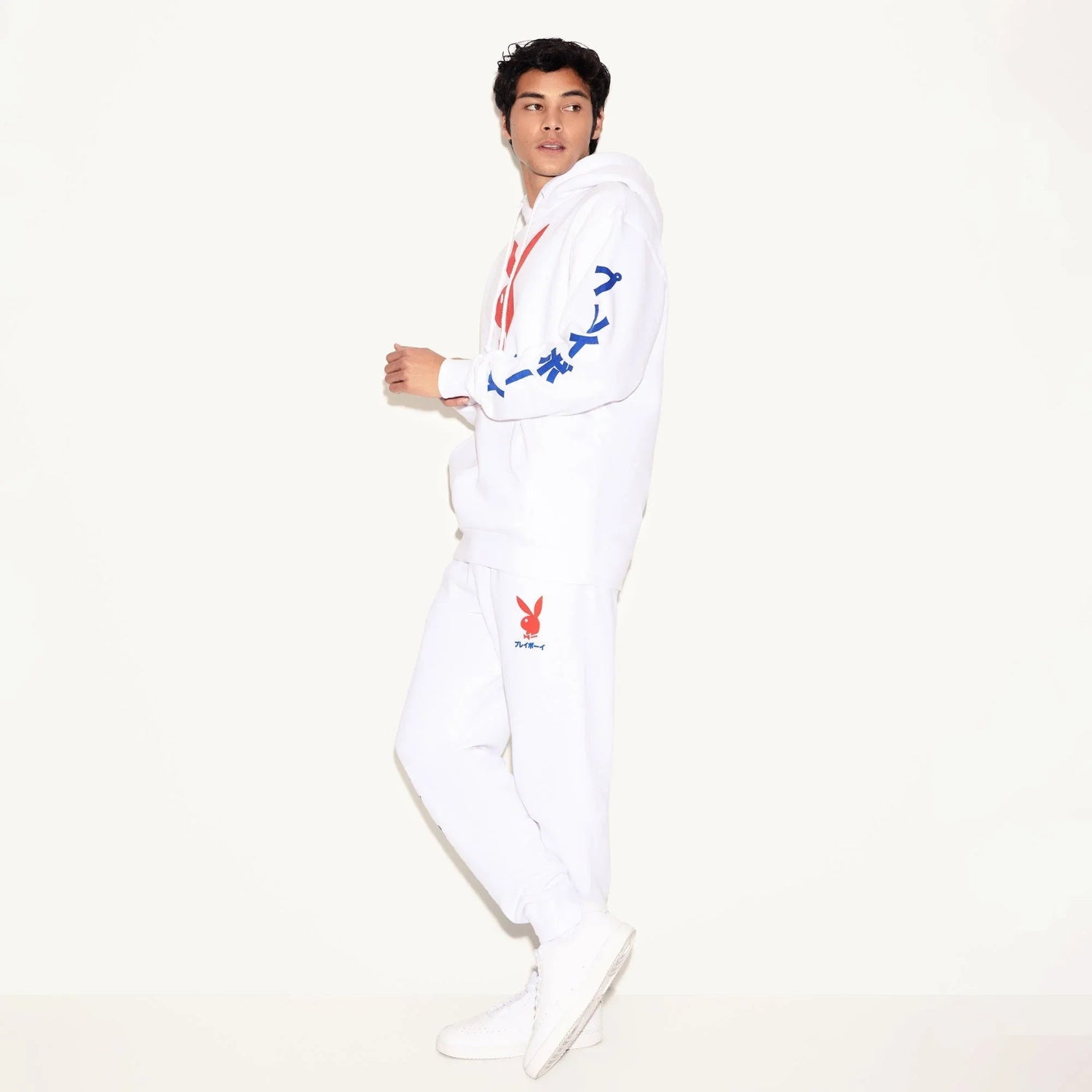 Man wearing white hoodie and sweatpants with red bunny logo and blue Japanese text on sleeve