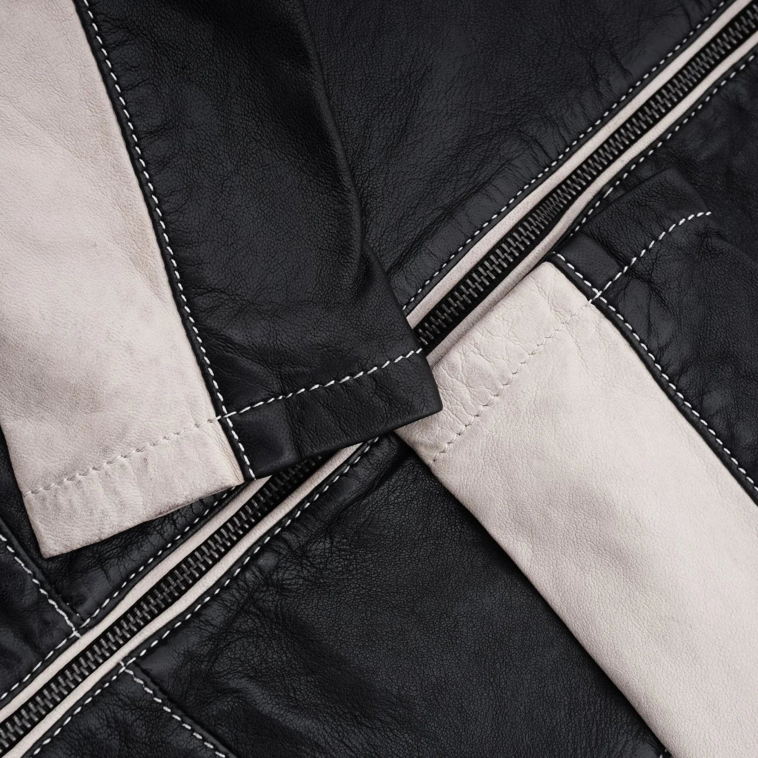 Close-up of women's black and white leather jacket with zipper and contrast stitching