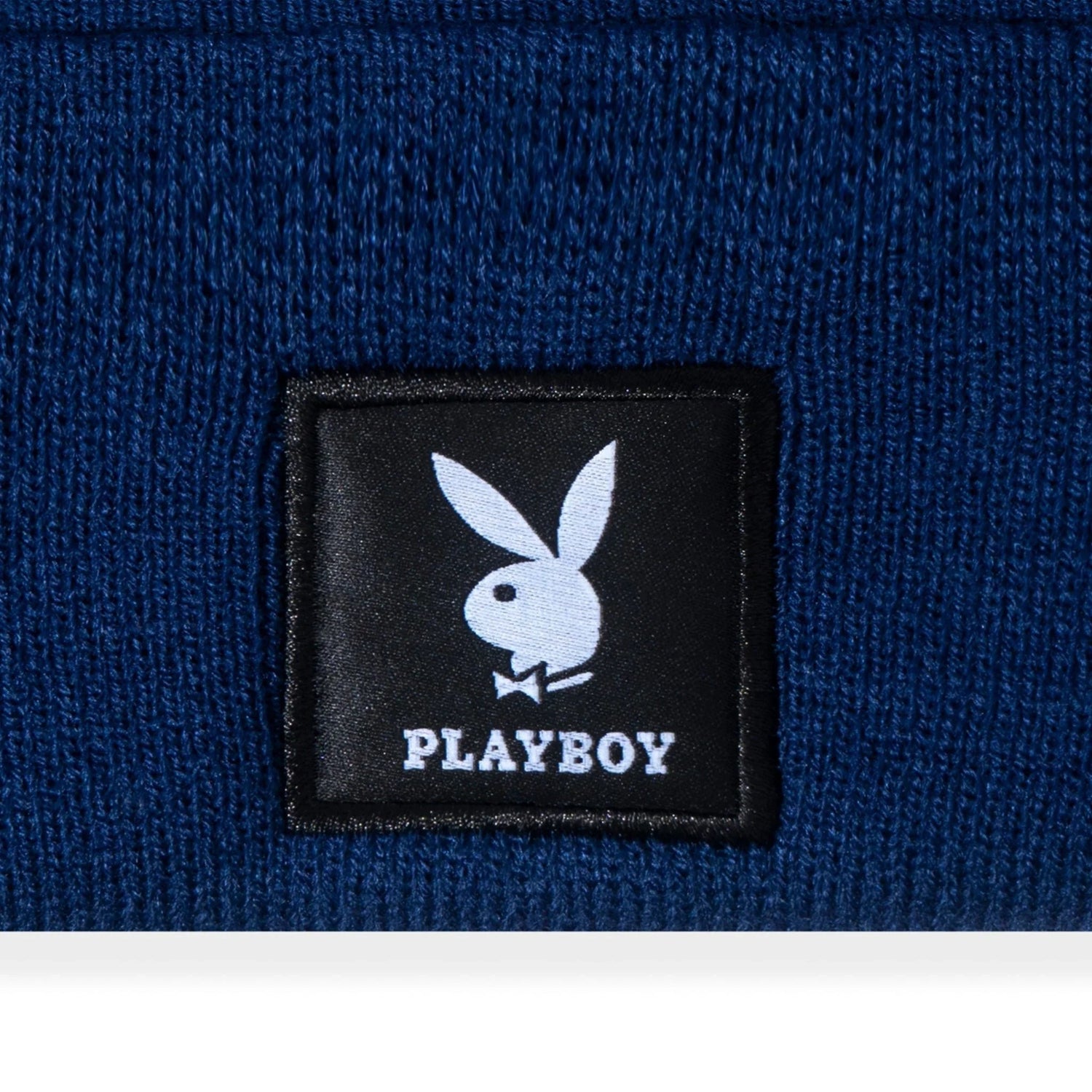 Blue knit beanie with black patch featuring white bunny logo and text
