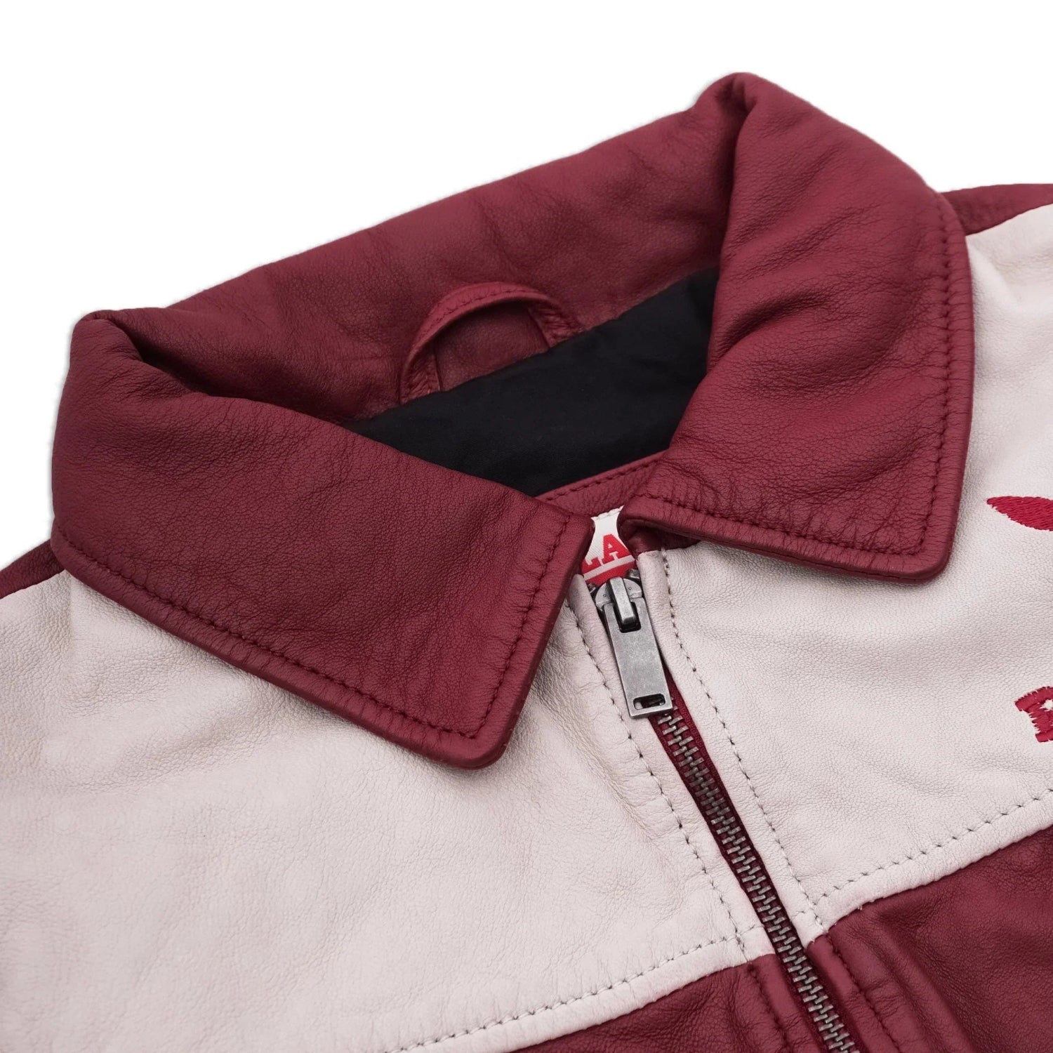 Close-up of a women's leather jacket with maroon collar, white panel, and silver zipper