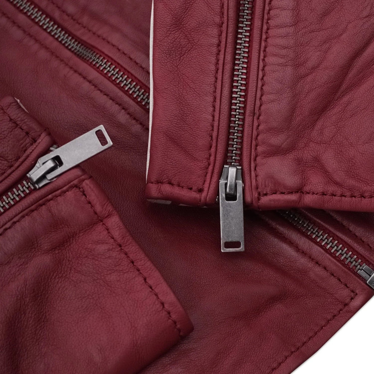 Close-up of maroon women's leather jacket with silver zippers and textured finish