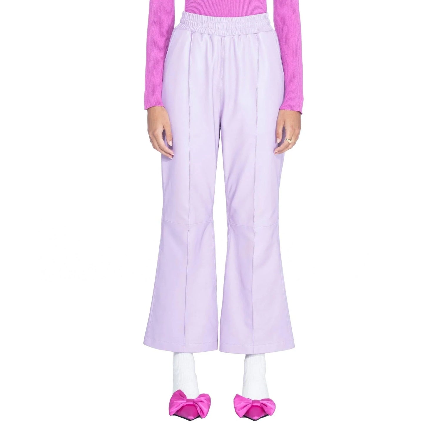 Woman wearing light purple leather flare pants with pink sweater and pink bow shoes