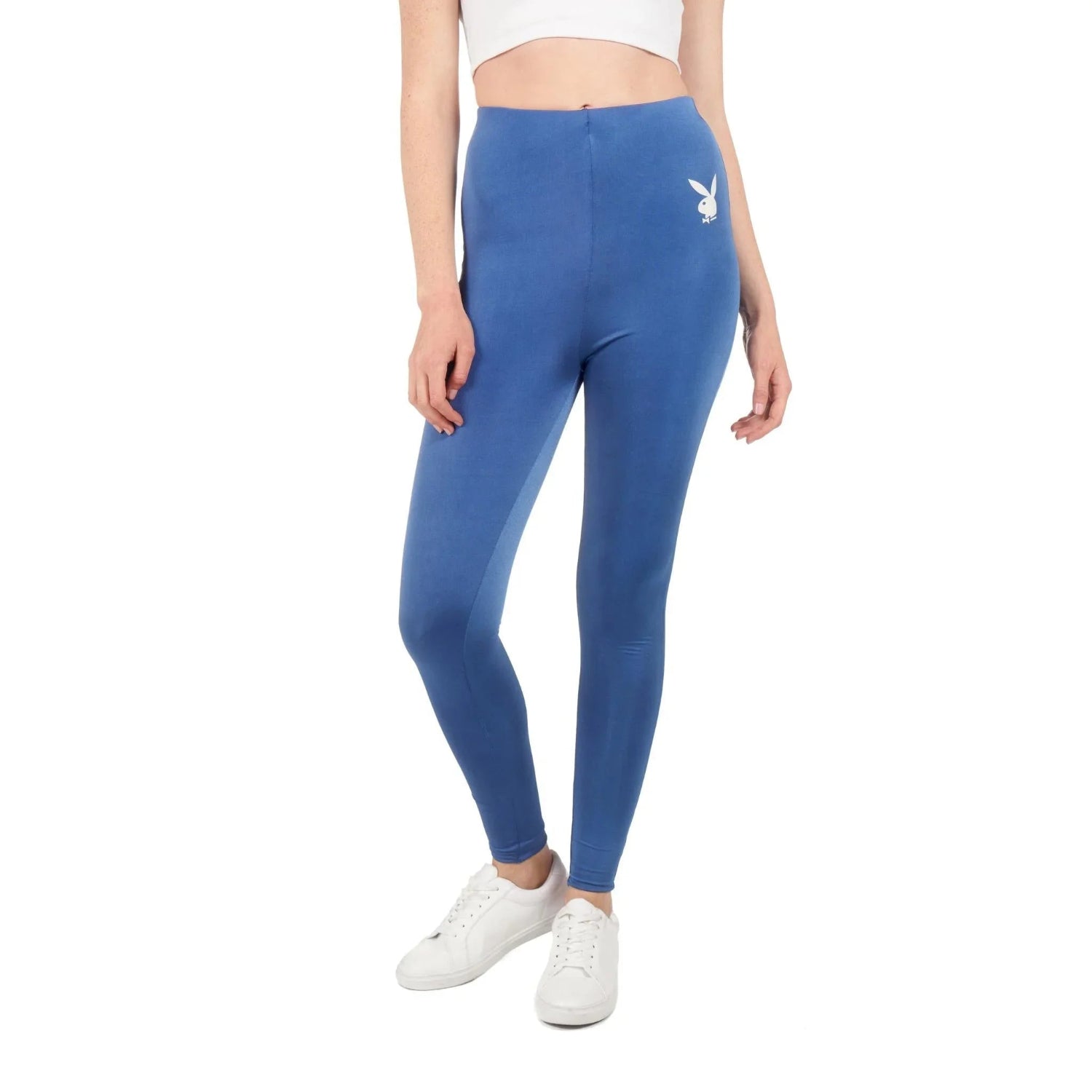 Woman wearing blue high-waisted leggings with white bunny logo and white sneakers