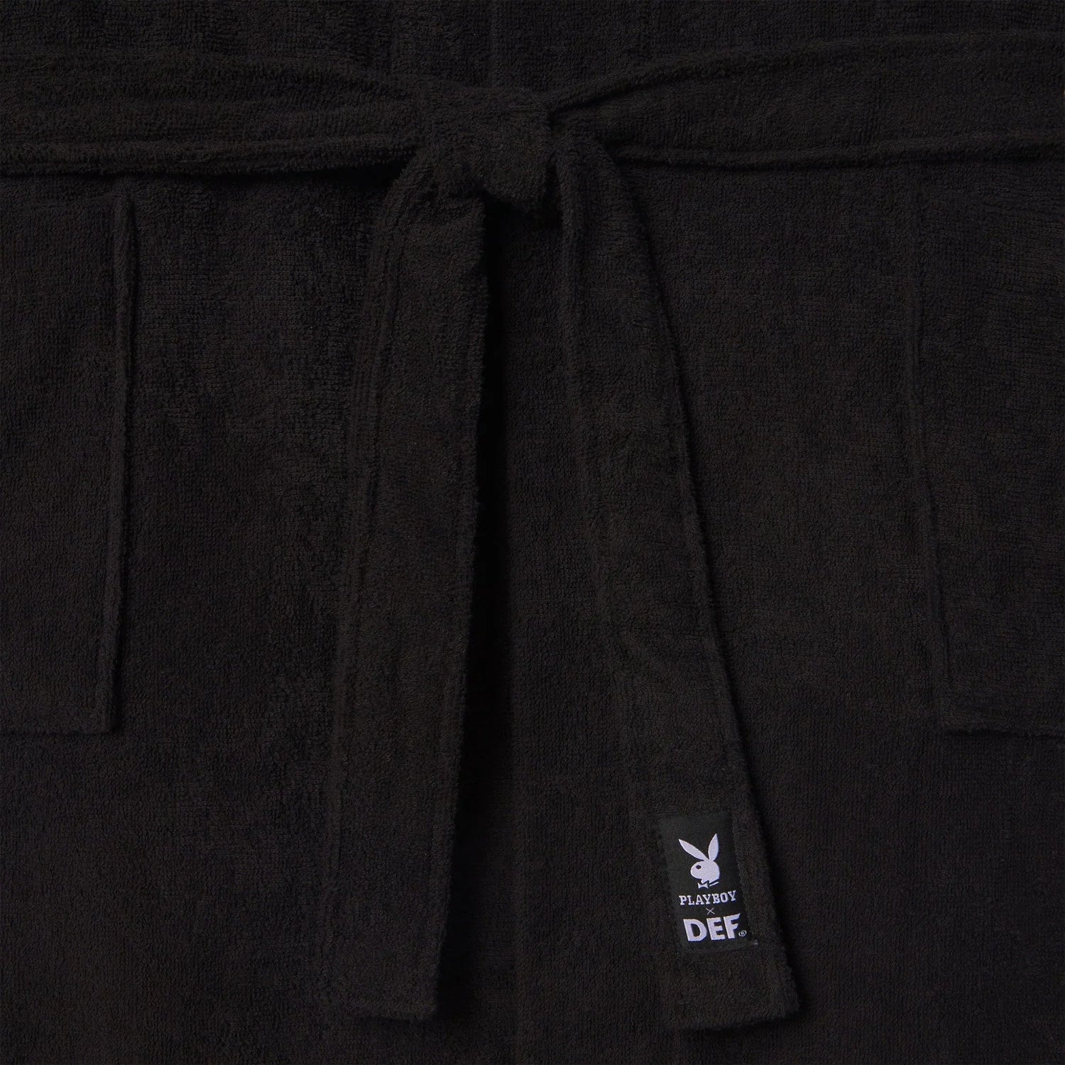 Black terry cloth bathrobe with front tie belt, side pockets, and visible label tag.