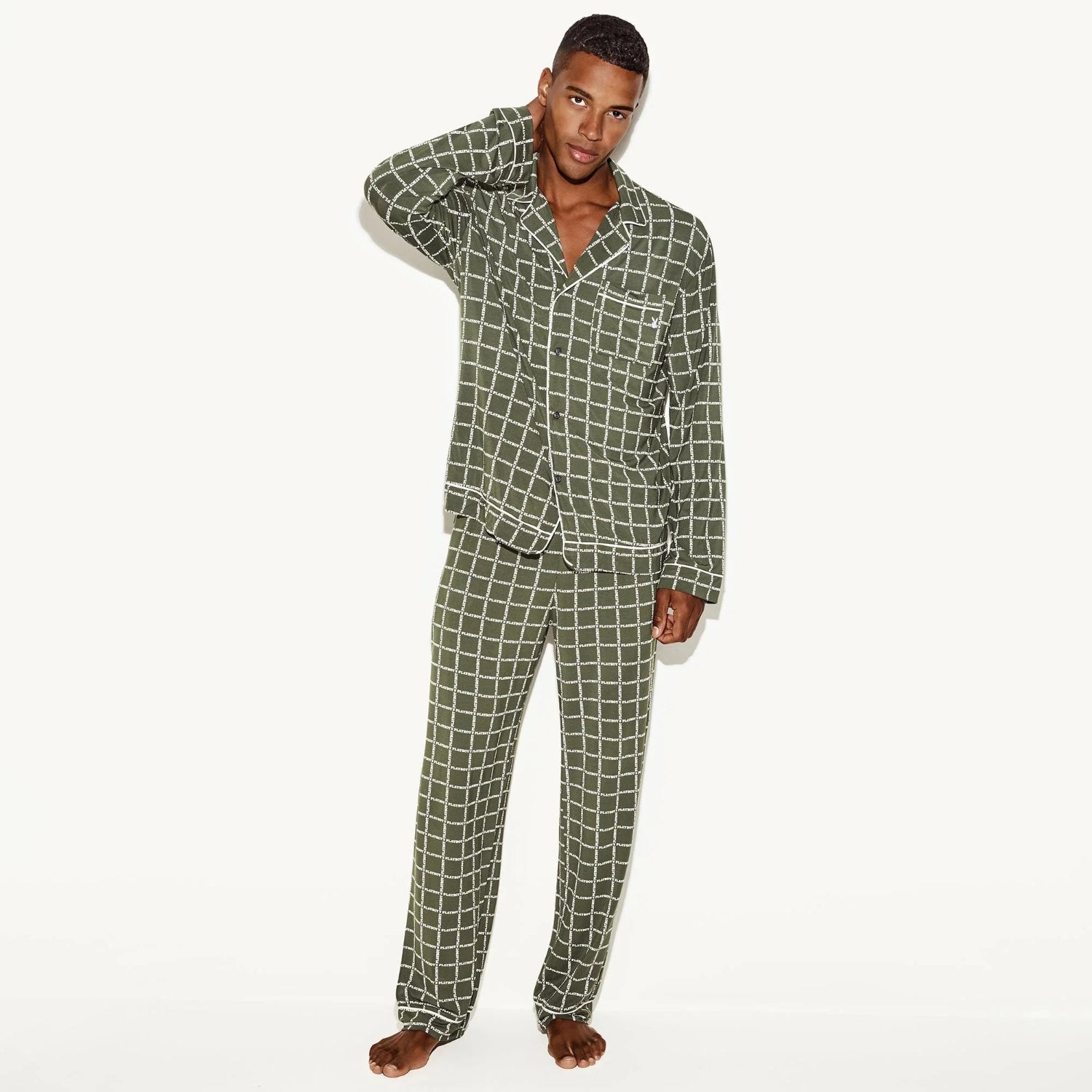 Man wearing green checkered men's classic sleep set pajamas, standing barefoot.