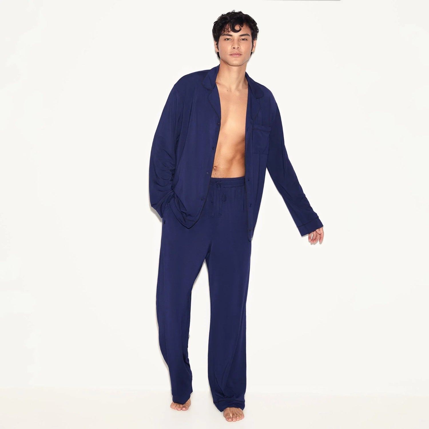 Man wearing navy blue classic men's sleep set with long sleeve top and pants