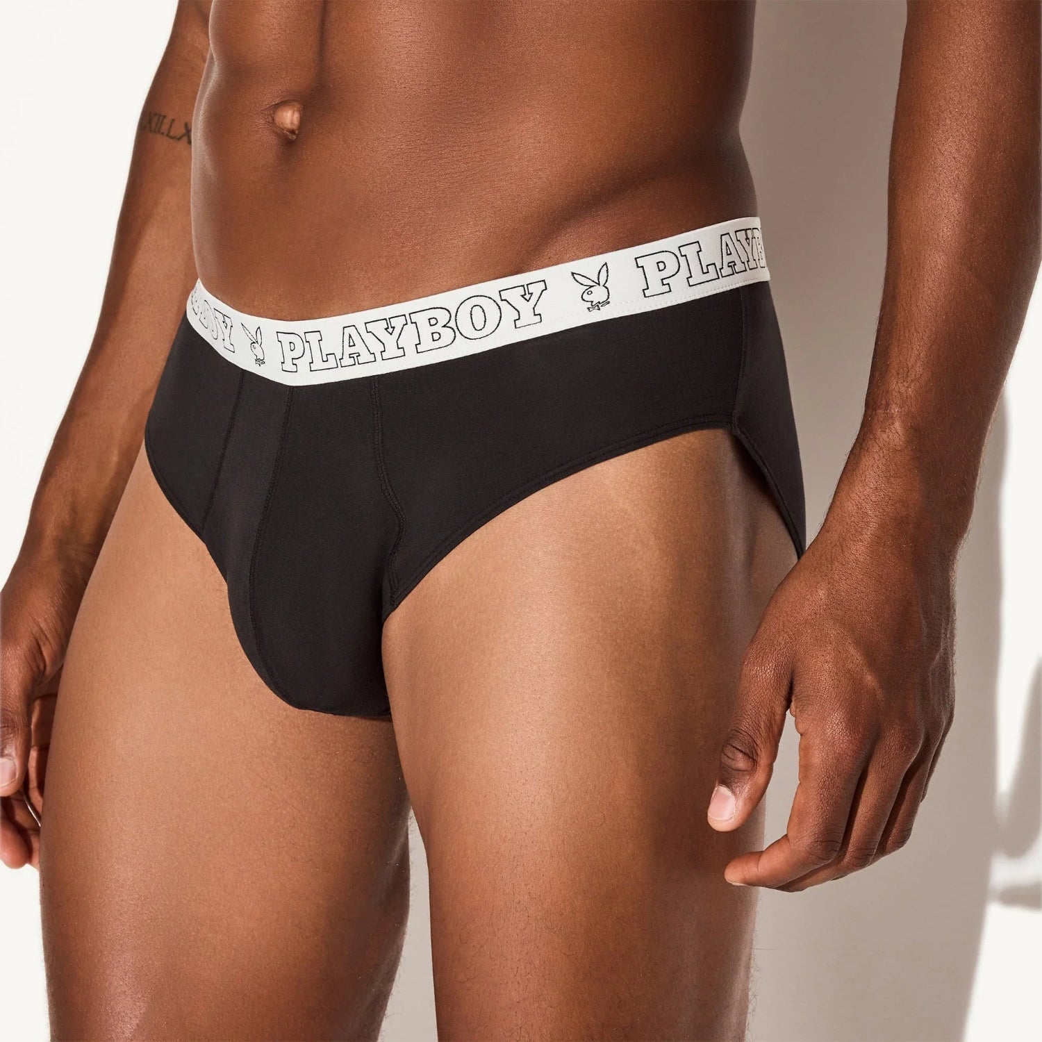 Men’s black modal briefs with white logo waistband, close-up front view