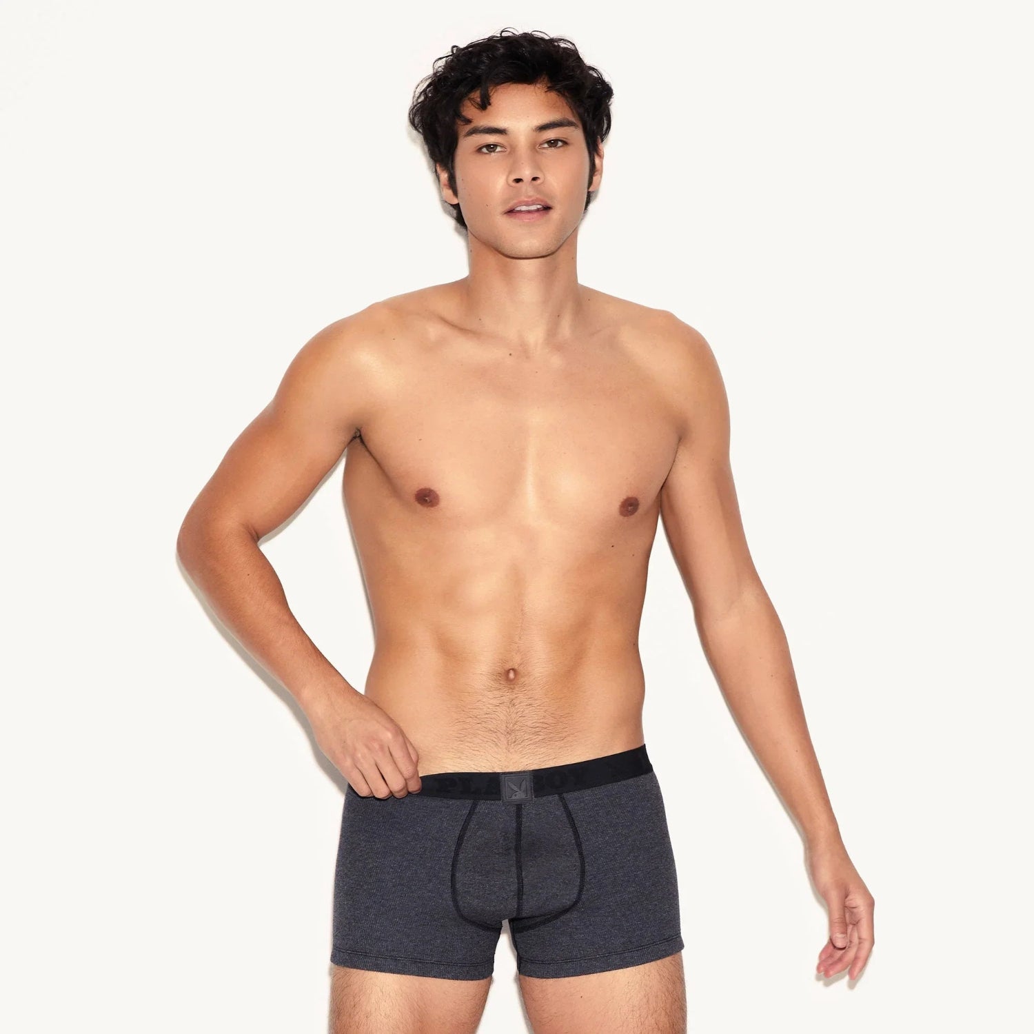 Male model wearing charcoal ribbed men's trunk underwear with black waistband on white background