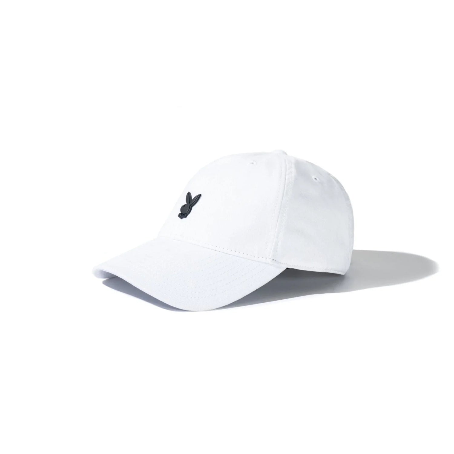 White dad hat with black metal rabbit head pin logo on front, angled on white background