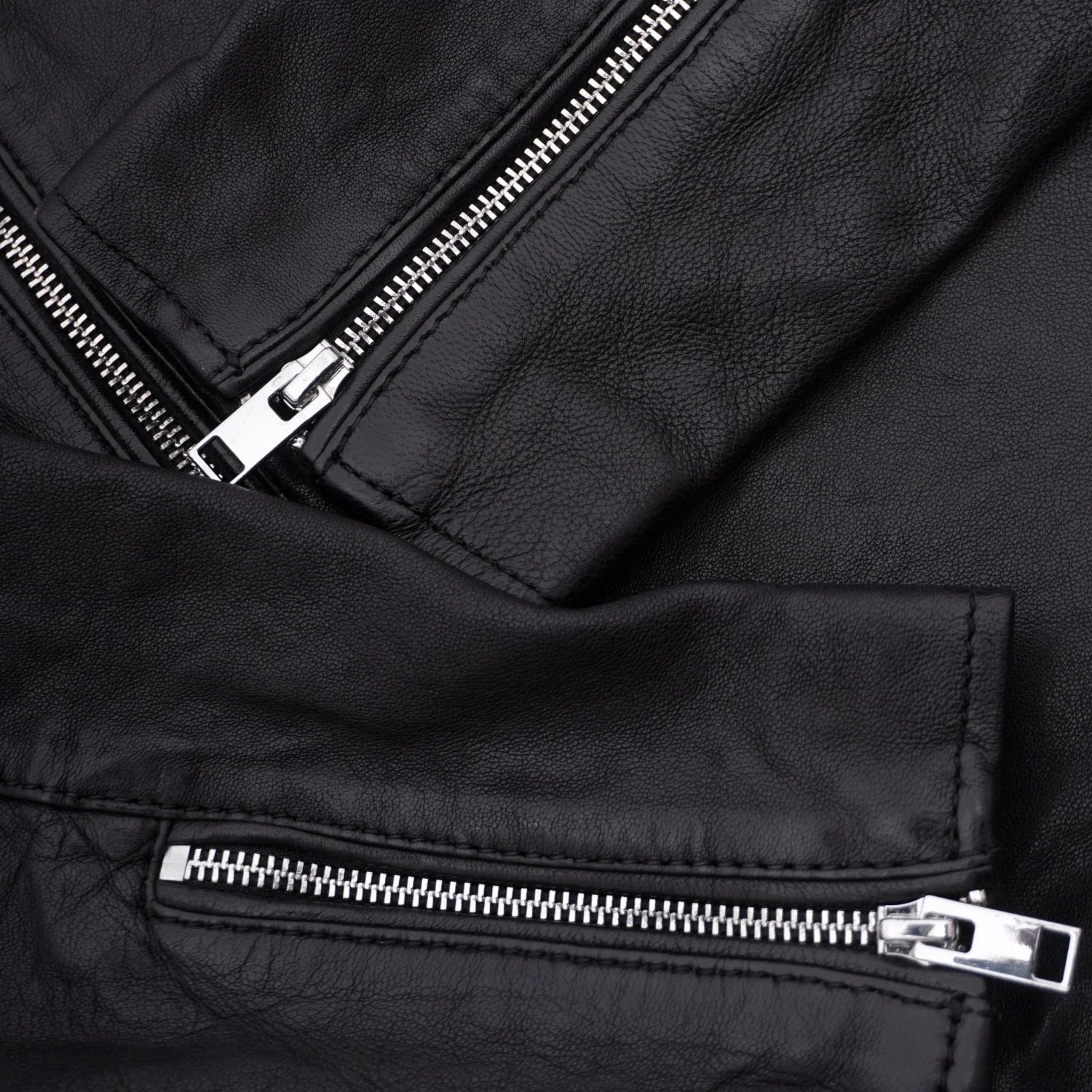 Close-up of black men's leather jacket with silver zippers and textured material
