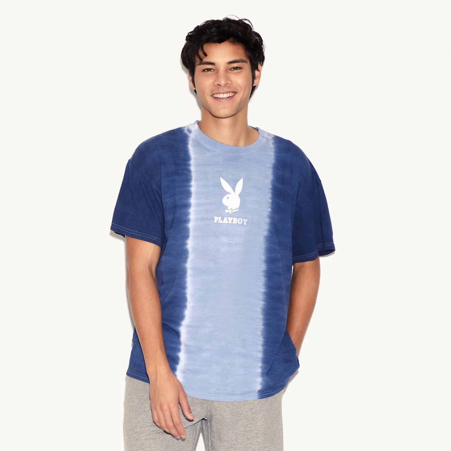 Man wearing blue tie-dye t-shirt with white bunny logo and text on front