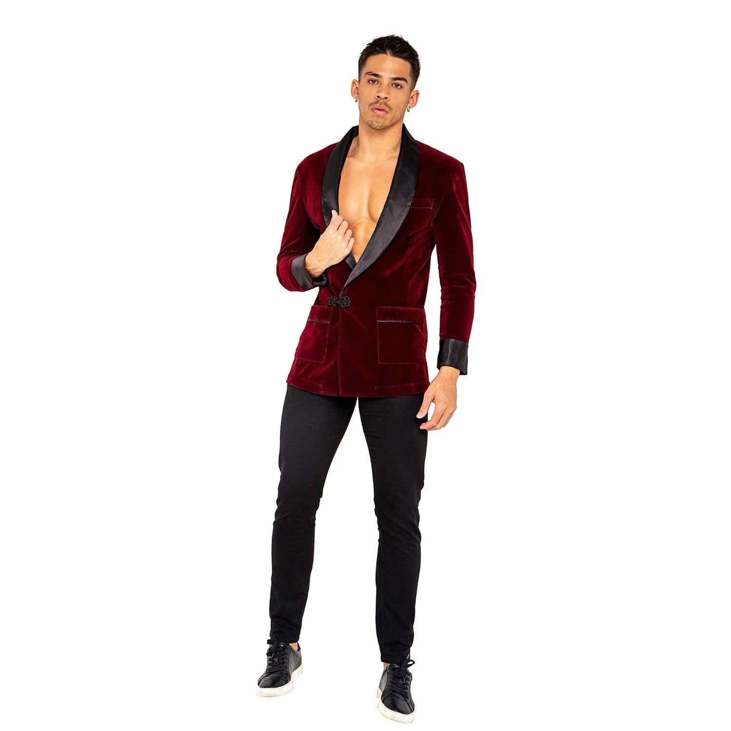 Man modeling a red velvet smoking jacket with black lapels and cuffs, black pants, and sneakers
