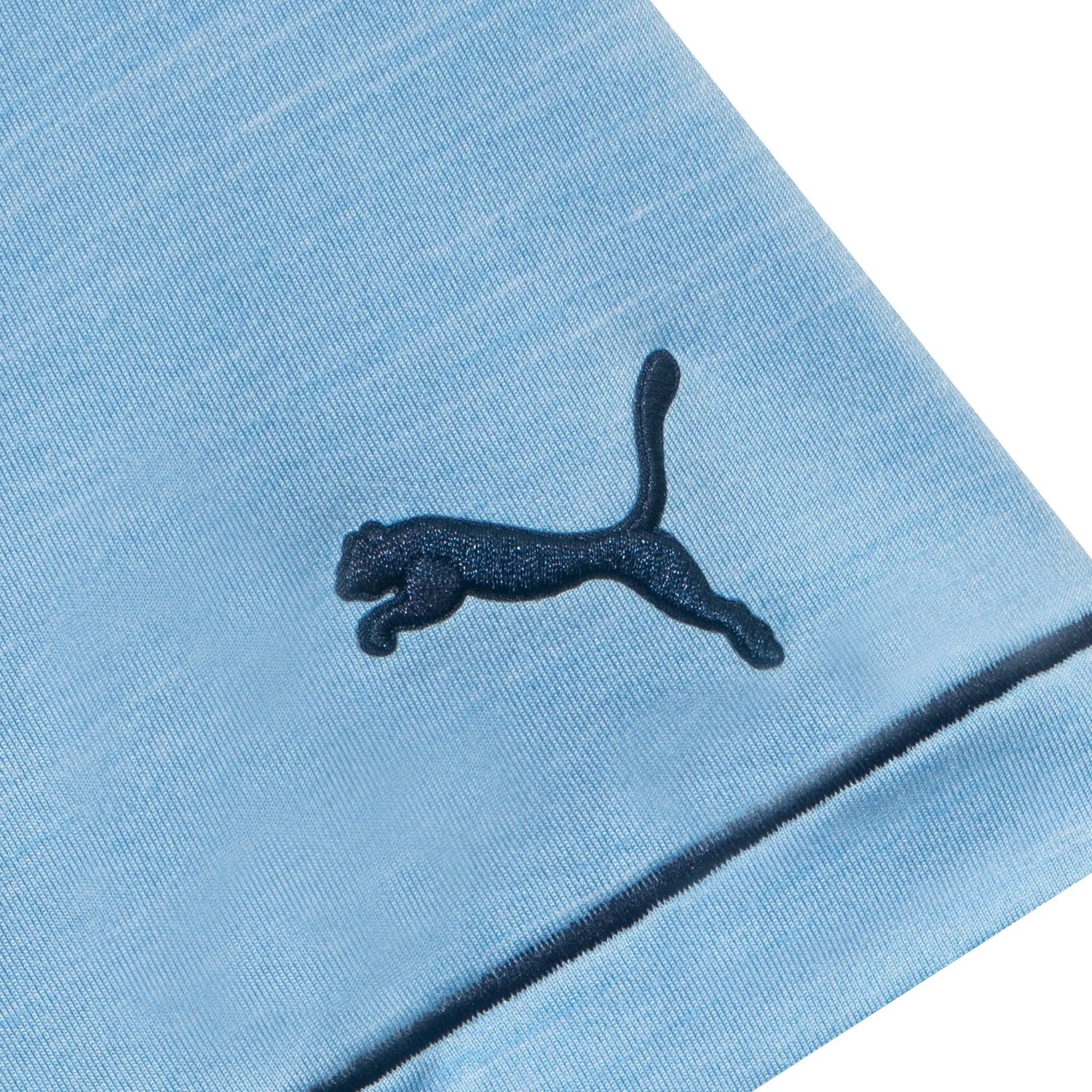 Close-up of light blue golf polo shirt sleeve with dark puma logo embroidery