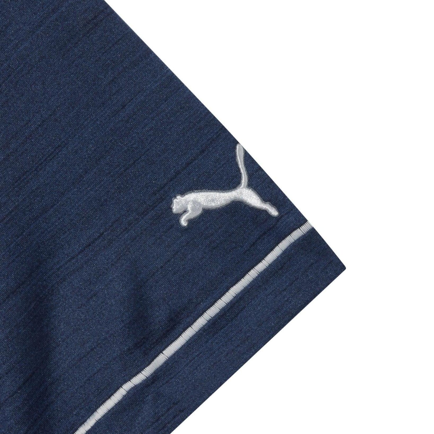 Close-up of navy blue performance polo sleeve with white logo and contrasting trim.