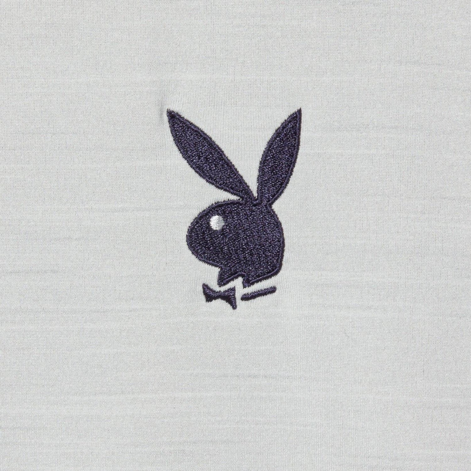 Black bunny head logo embroidered on light grey fabric close-up
