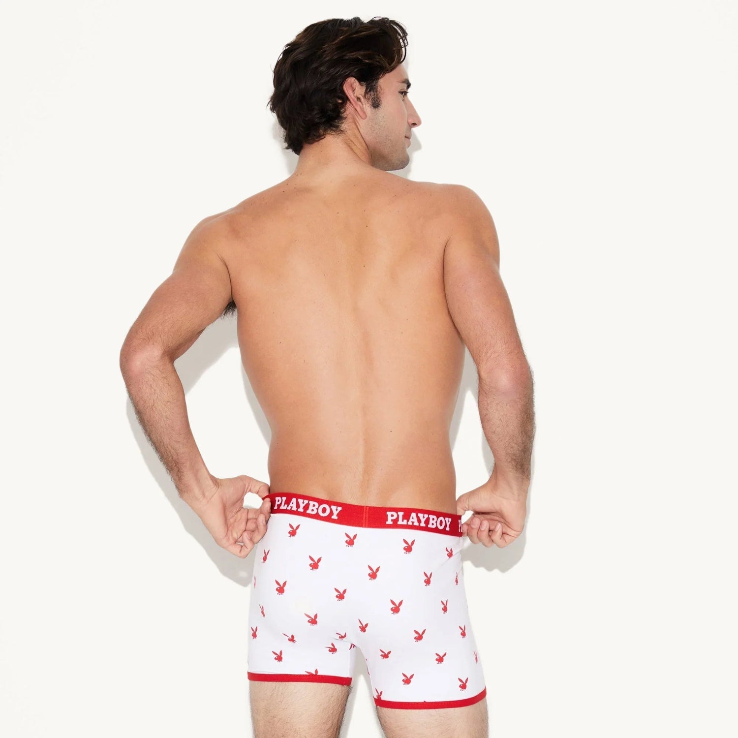 Man wearing white boxer briefs with red rabbit head print and red waistband, rear view