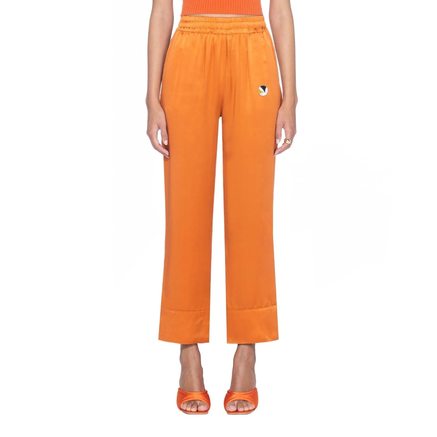 Women's orange silk lounge pants with elastic waist and embroidered logo, front view