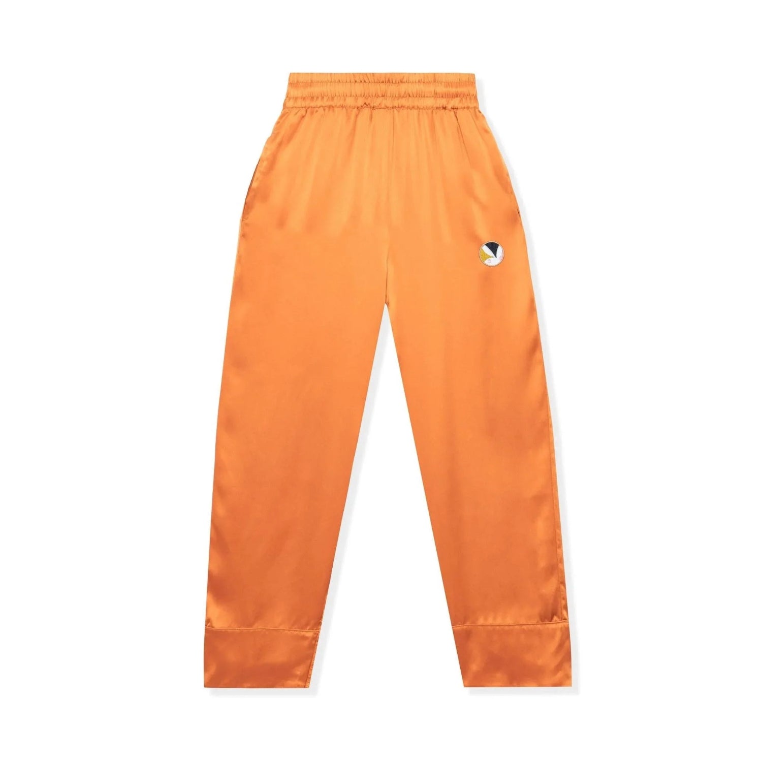 Orange silk lounge pants with elastic waistband and embroidered logo on thigh, flat lay.