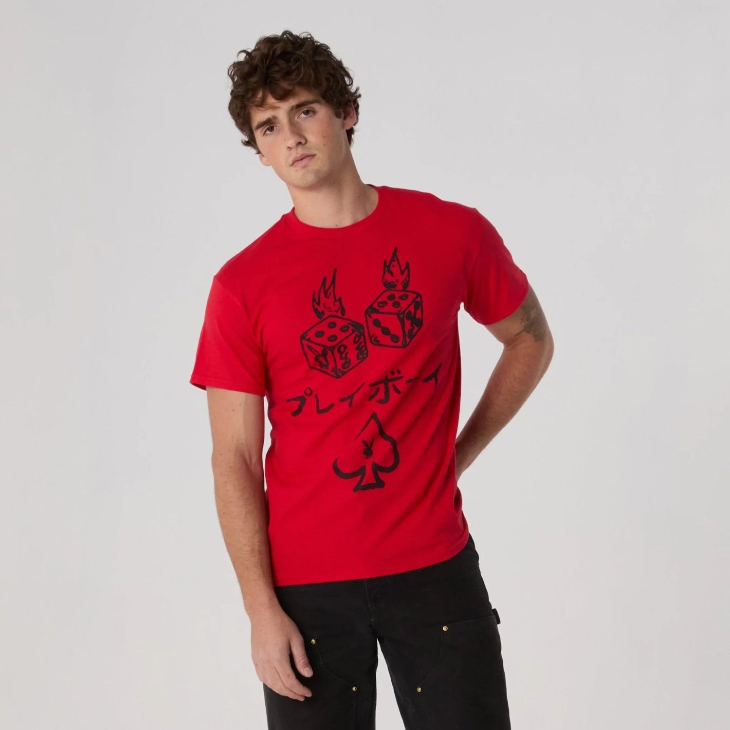 Man wearing red graphic tee with flaming dice, Japanese text, and spade symbol, casual fashion