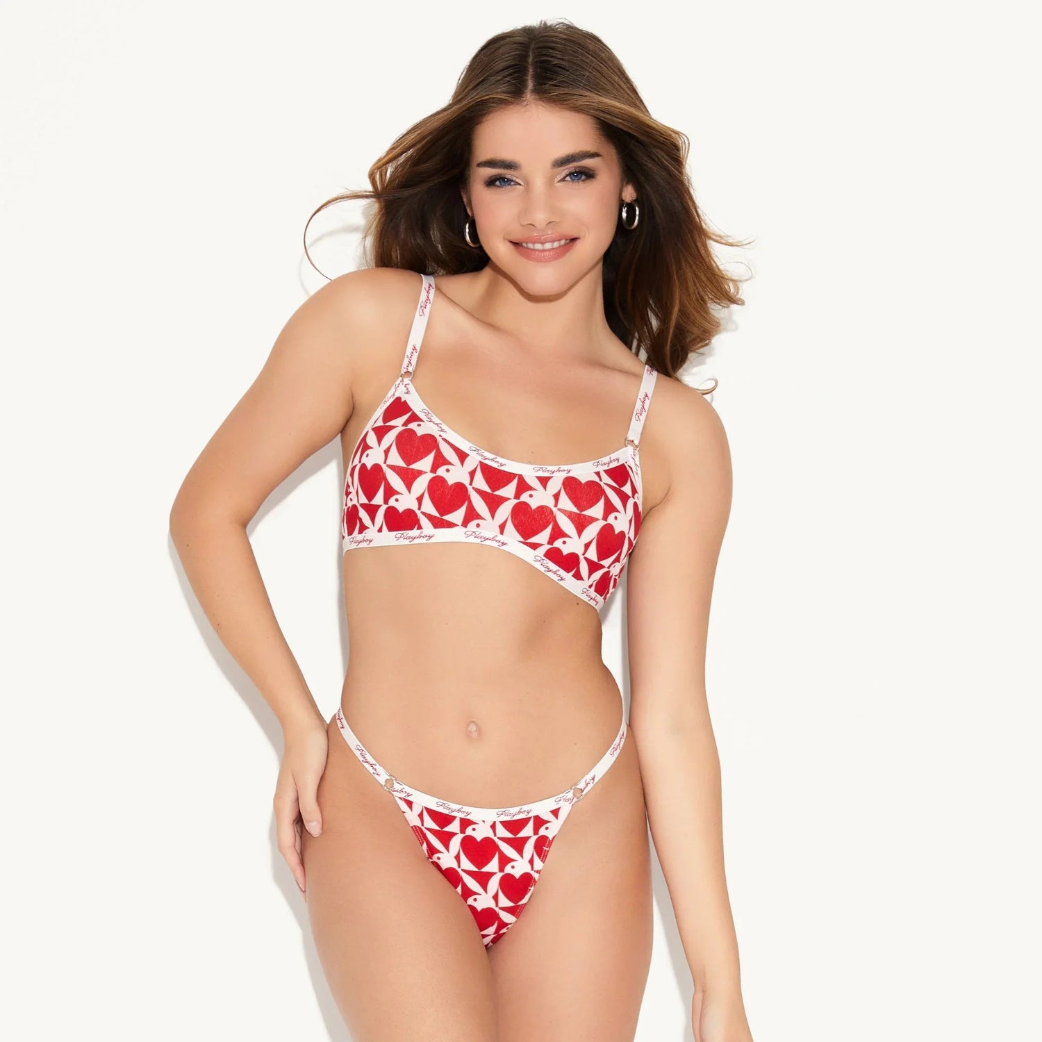Woman wearing red and white heart print scoop bralette and matching thong lingerie set