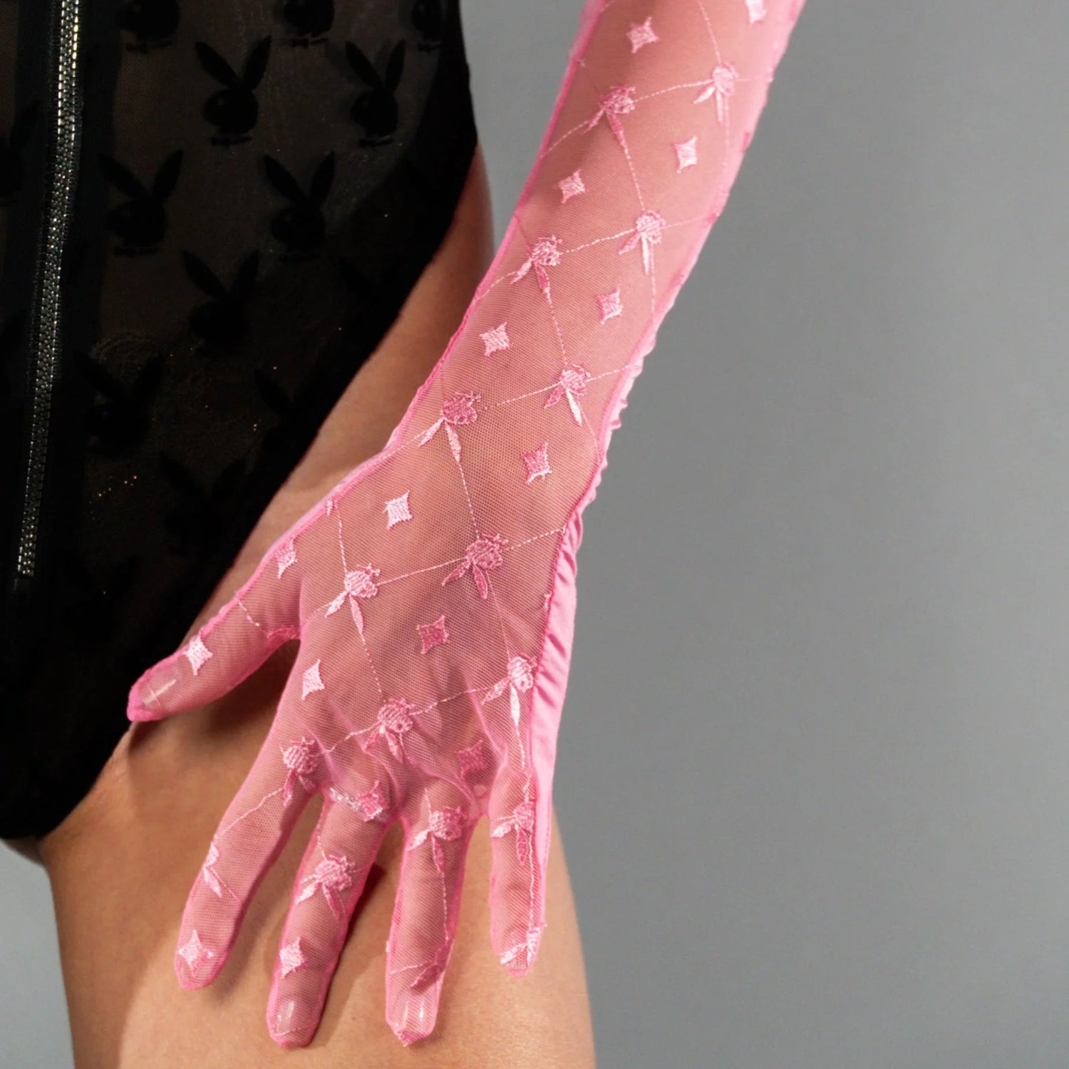 Sheer pink mesh gloves with embroidered pattern, worn with black bodysuit featuring bunny print