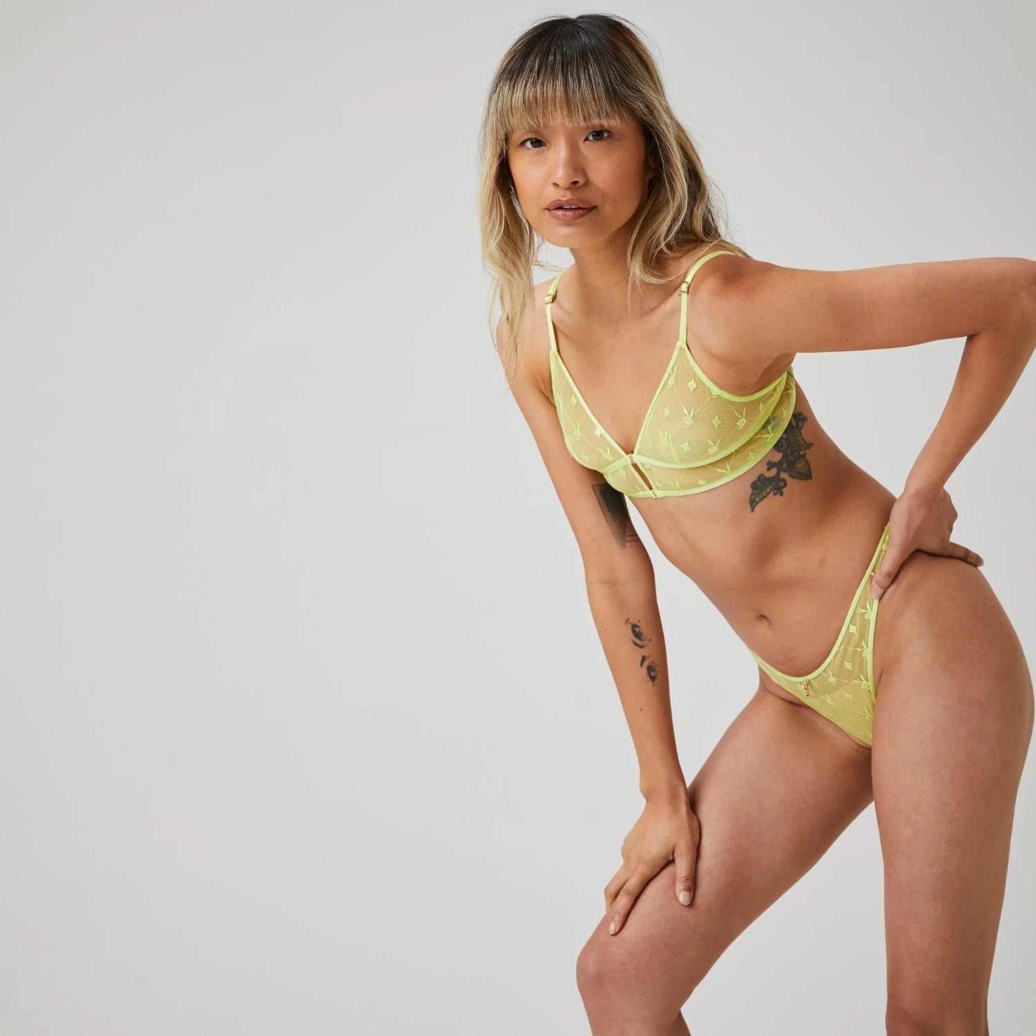 Woman wearing yellow mesh longline triangle bralette and matching thong lingerie set