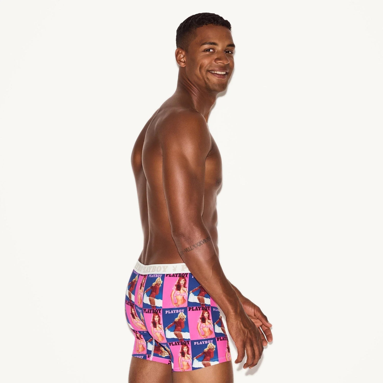 Man modeling colorful boxer briefs with vintage magazine cover print on white background