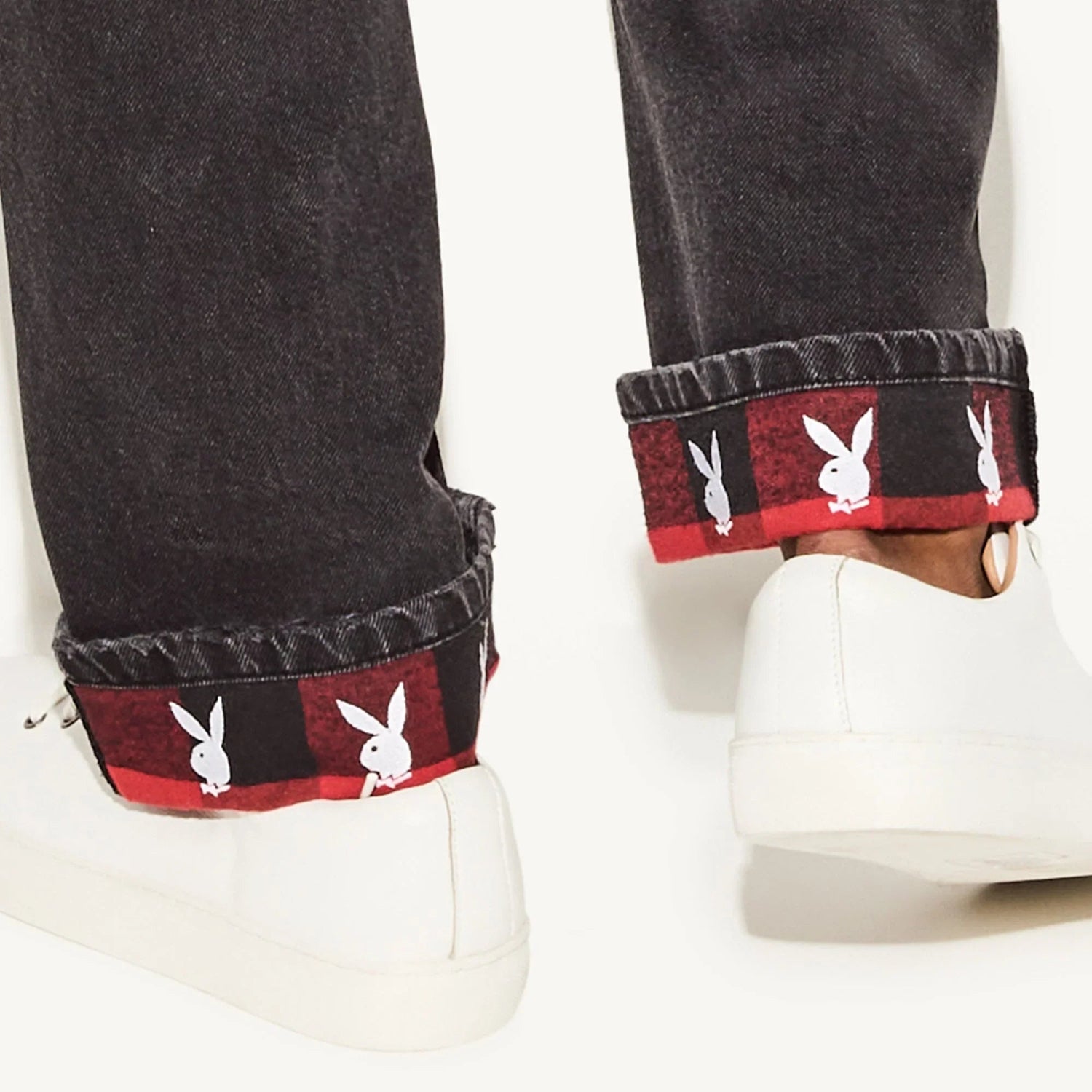 Vintage black straight leg jeans with red plaid cuff and white bunny logo, paired with white sneakers