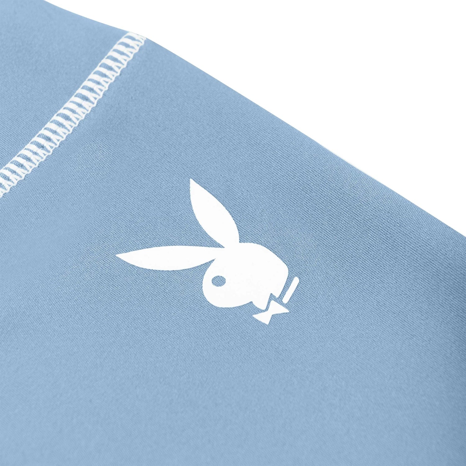 Close-up of light blue women's active legging with white bunny head logo and visible stitching