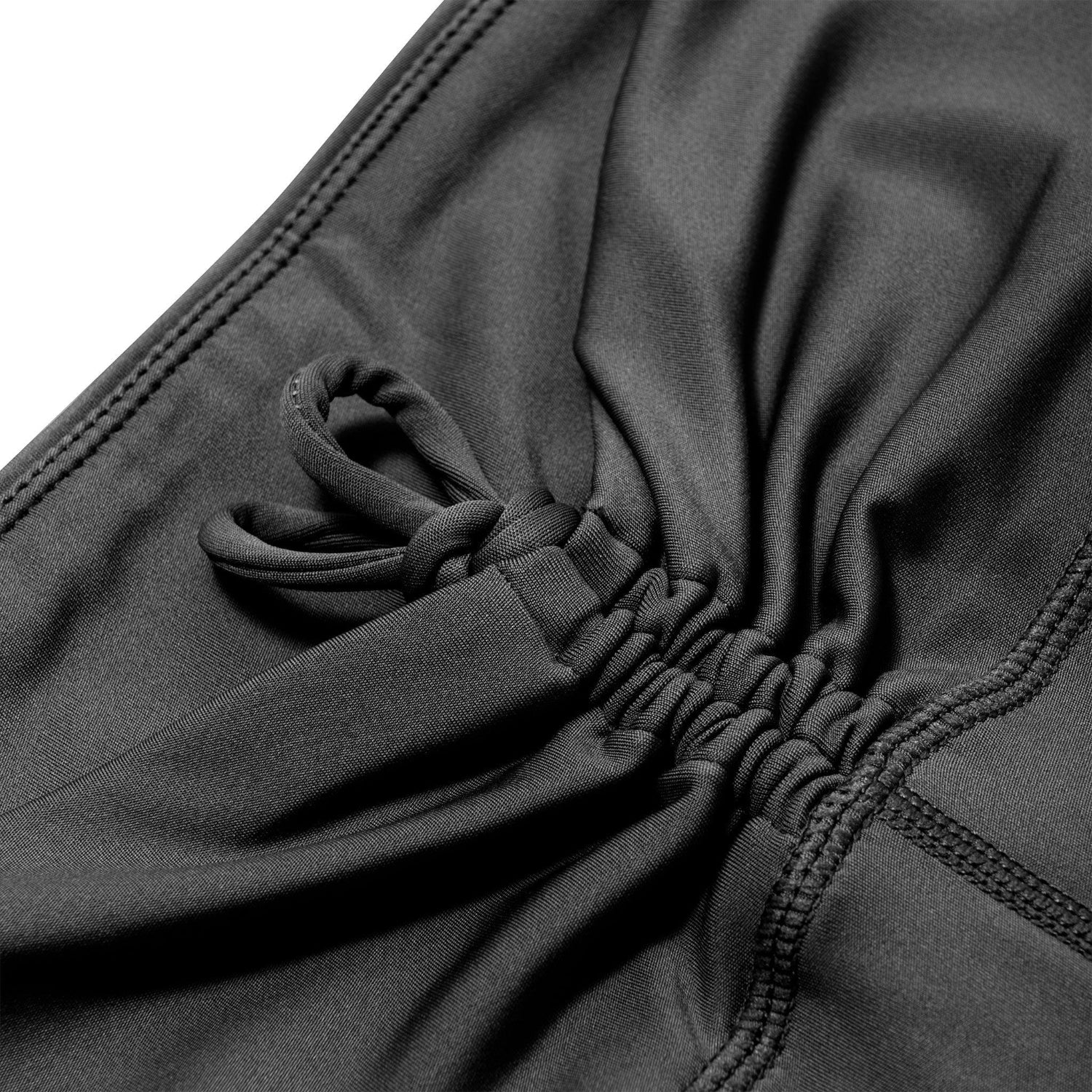 Close-up of black ruched tie detail on women's active bike shorts with stretch fabric