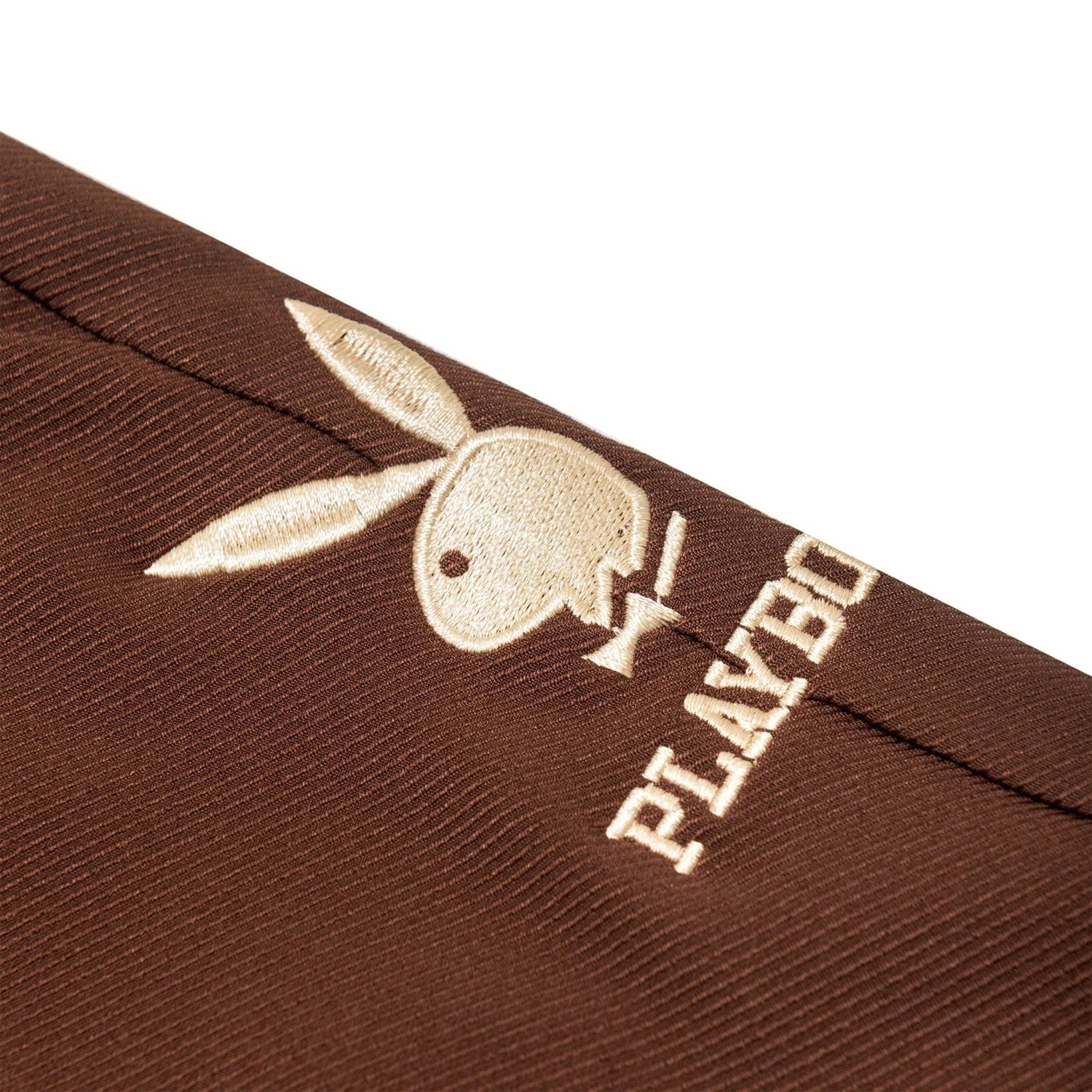 Close-up of brown women's boyfriend trousers with embroidered bunny logo and text detail