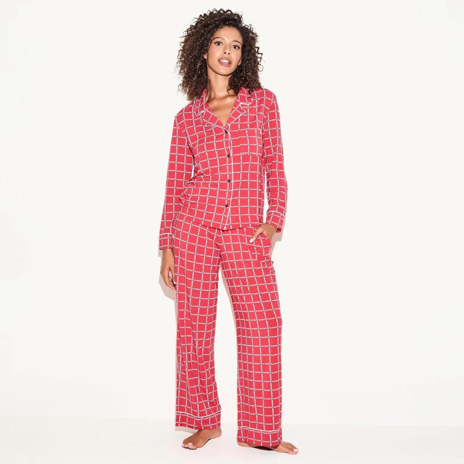Woman wearing red plaid long sleeve pajama set with button-up top and wide-leg pants