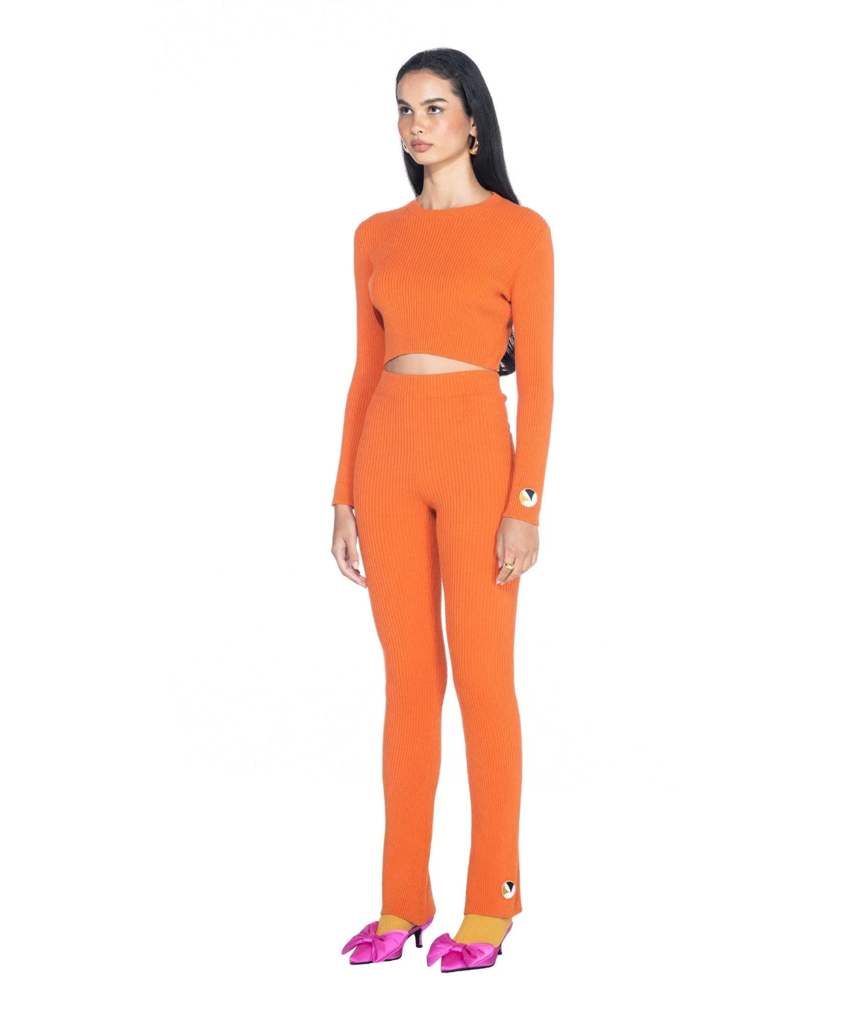 Woman wearing orange ribbed cropped long sleeve top and matching high-waisted pants