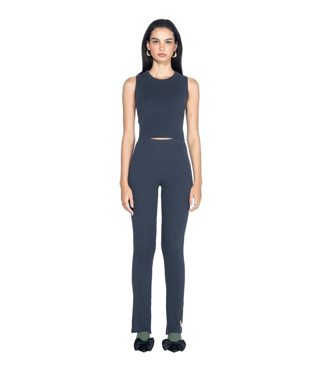 Woman wearing dark ribbed cropped tank top and matching high-waisted pants, front view