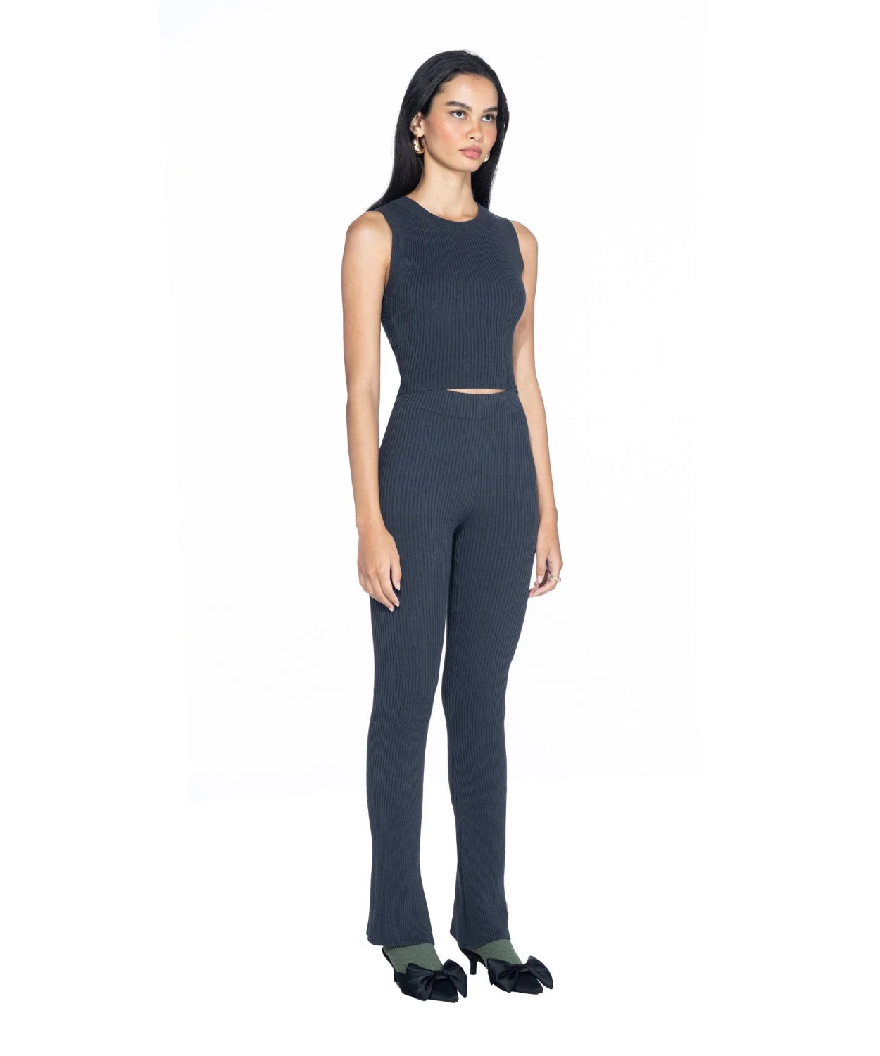 Woman wearing a black ribbed cropped tank top and matching high-waisted pants set.