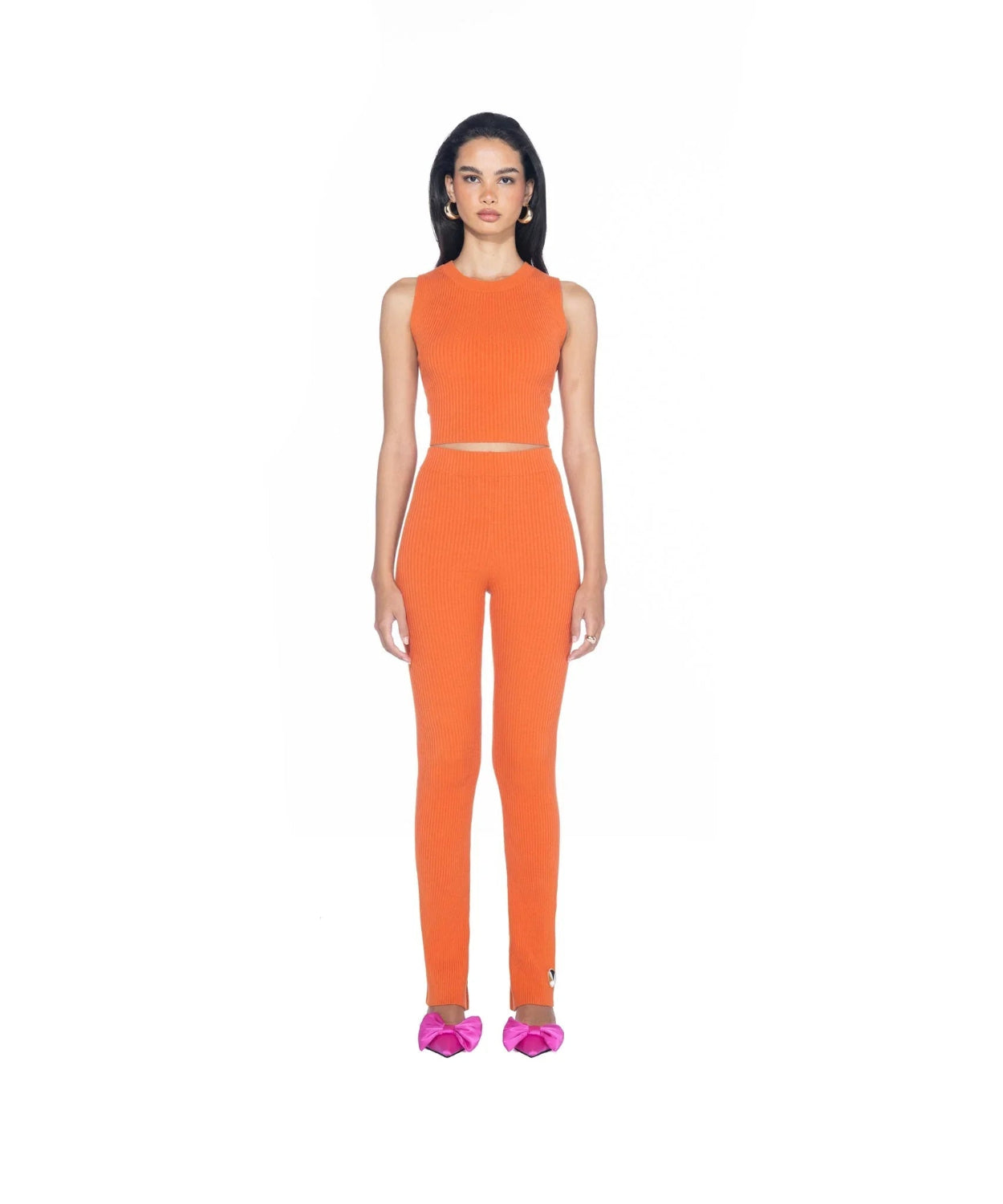 Woman modeling orange ribbed cropped tank top and leggings set with pink bow shoes